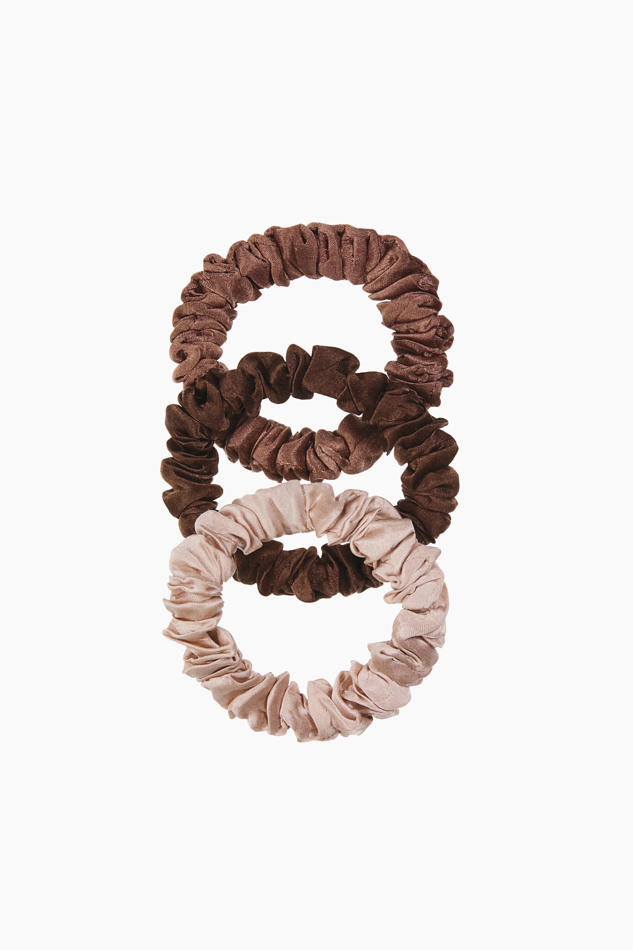 Visualizza immagine più grande: Tre scrunchie in seta di gelso elasticizzata sono appoggiate in una pila verticale, mettendo in risalto un design arricciato e increspato con una finitura morbida e luminosa. Gli scrunchie appaiono in tre tonalità neutre, tra cui un marrone medio in alto, un marrone cioccolato scuro al centro e un beige champagne chiaro in basso.