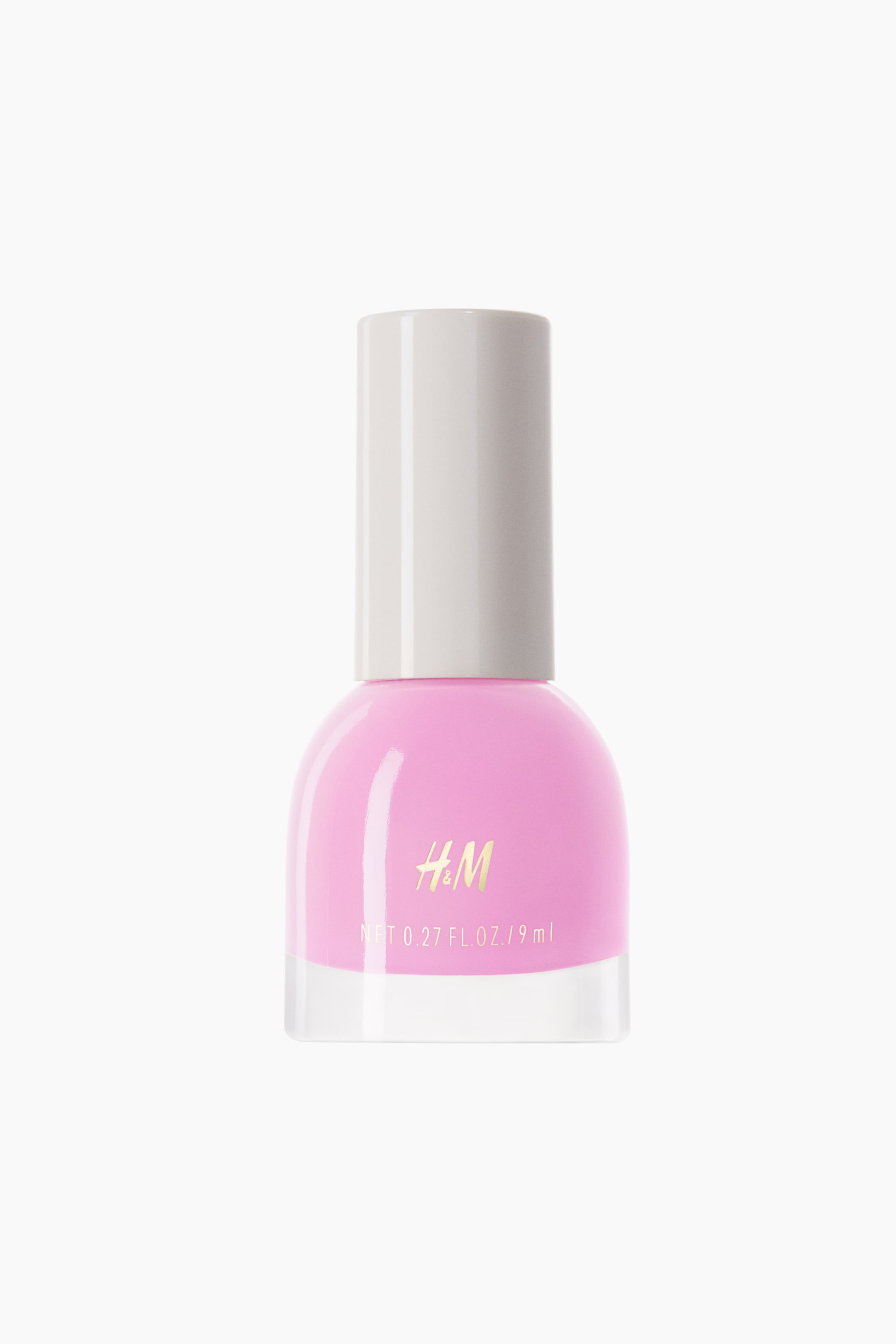 View larger image: The nail polish bottle is positioned facing forward, showcasing a clear rectangular base that seamlessly transitions into a rounded pink body. The bottle is topped with a white cylindrical cap, and the gold "H&M" branding along with volume details are prominently displayed on the pink section.