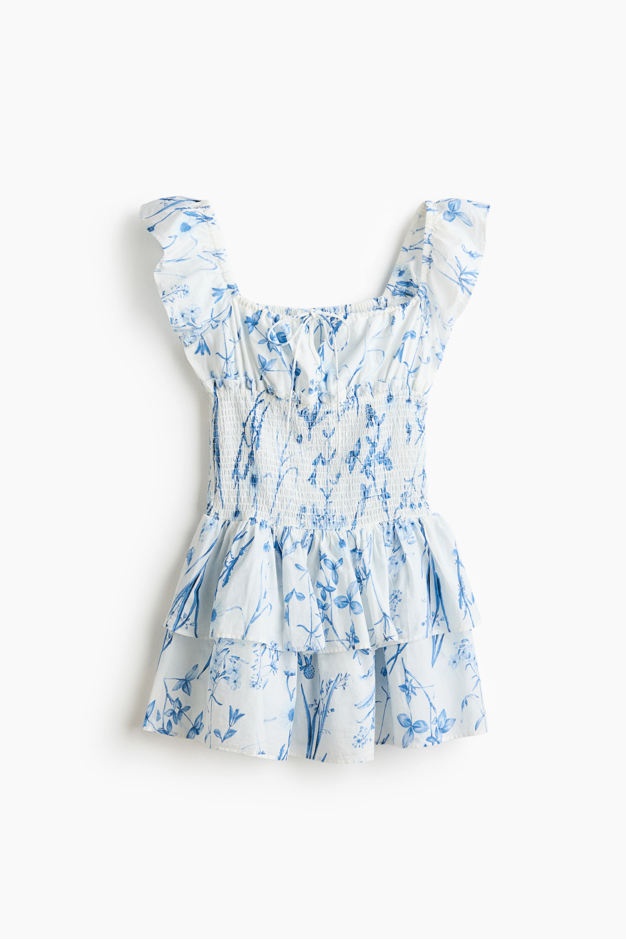 View larger image: "This short dress flaunts a blue floral print on white fabric, featuring an elasticated square neckline with a drawstring tie and a petite front opening. Designed with flutter sleeves, a smocked bodice extending to the waist, and a tiered, flared skirt."