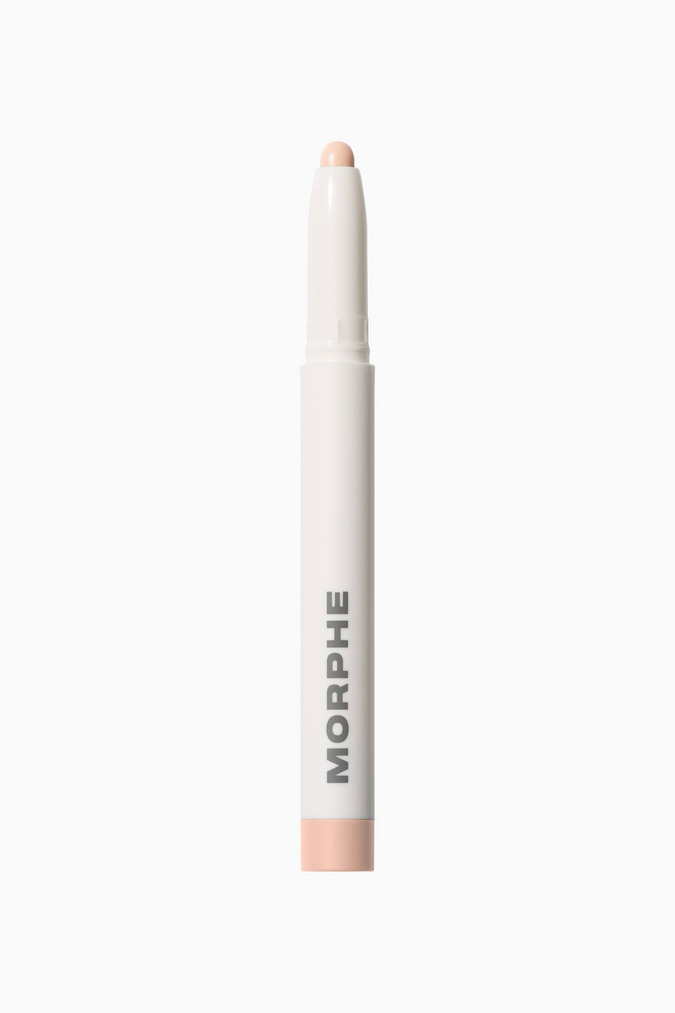 Vis større bilde: En hvit Morphe Shapelifter Micro Brightening Stick står vertikalt og viser en avrundet, lys ferskenfarget produktspiss på toppen. Den sylindriske hylsen har den grå «MORPHE»-logoen trykt vertikalt, med en matchende ferskenfarget kant som avslutter bunnen.