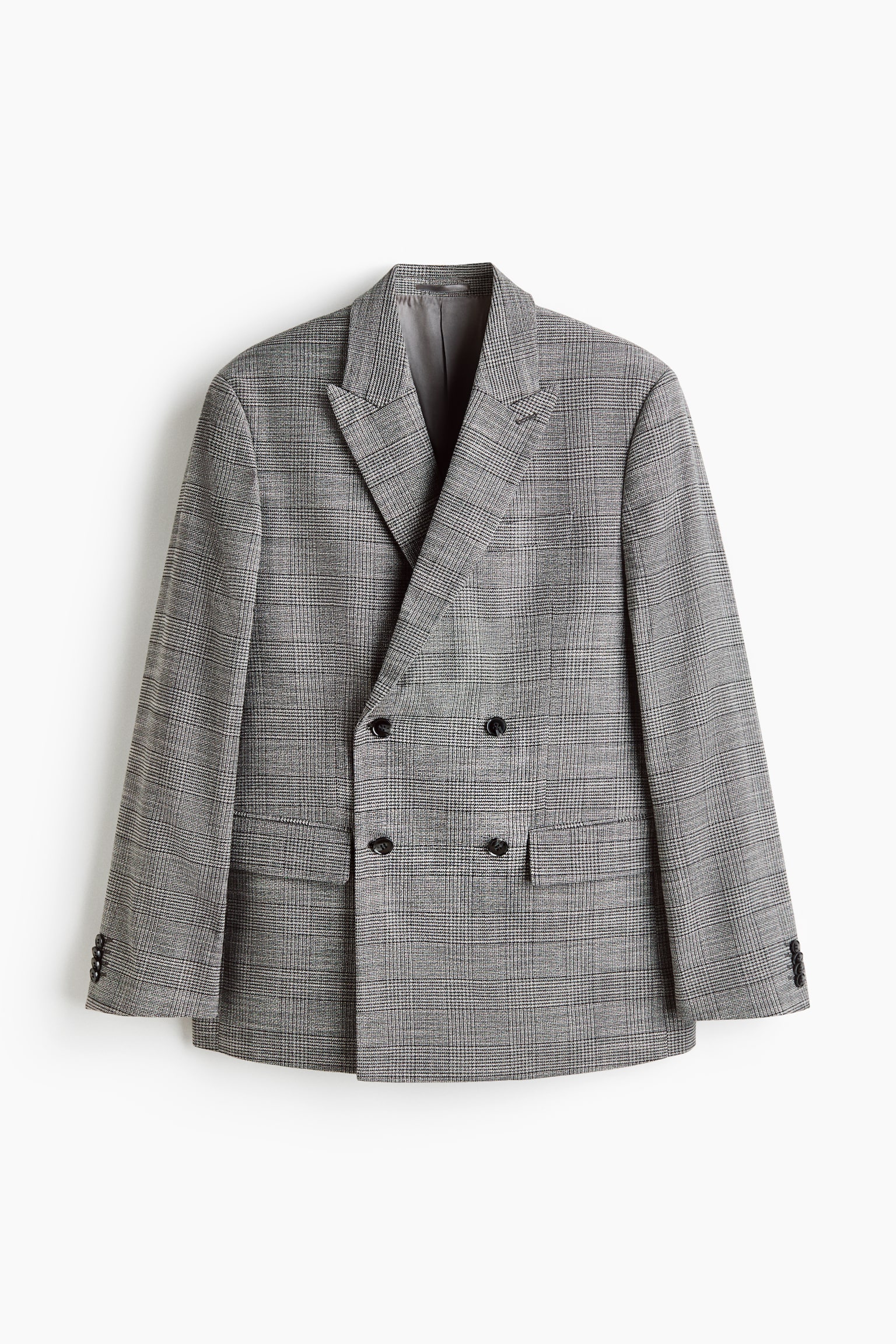 Un blazer croisé à carreaux gris est présenté de face, avec de larges revers à encoches et quatre boutons foncés sur la fermeture avant. Il présente également deux poches à rabat inférieures avec une poche à billet supplémentaire, et chaque manchette de manche affiche quatre boutons foncés. - 1