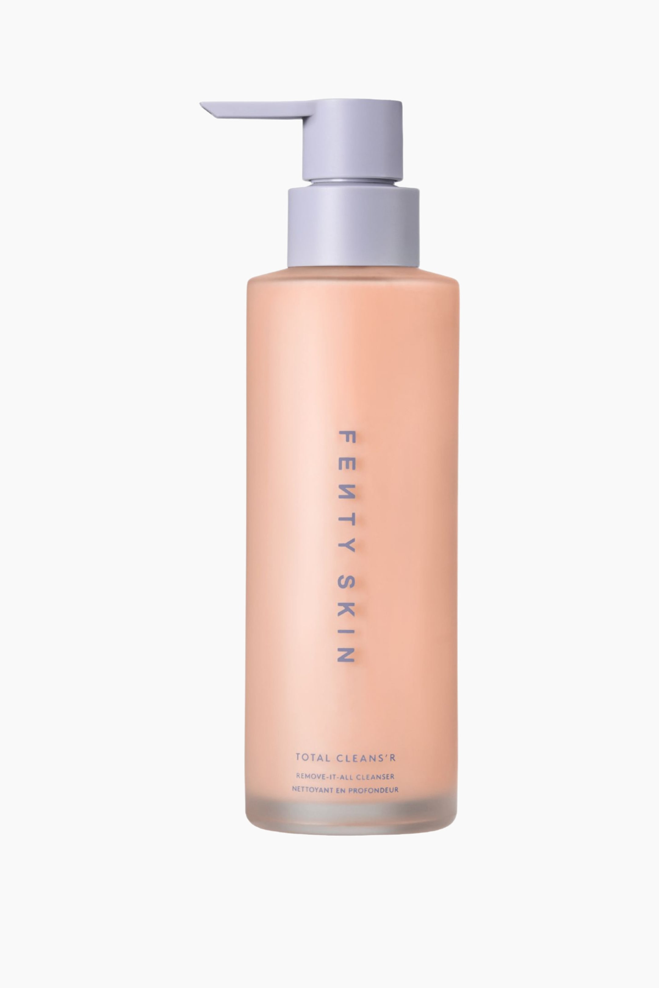 Visa större bild: En flaska Fenty Skin Total Cleans'r står upprätt och har en frostad, persikofärgad cylindrisk kropp samt en ljuslila pumpdispenser som pekar åt vänster. Den framåtvända flaskan visar vertikal ”FENTY SKIN”-märkning och produktdetaljer nära basen i en matchande lila font.