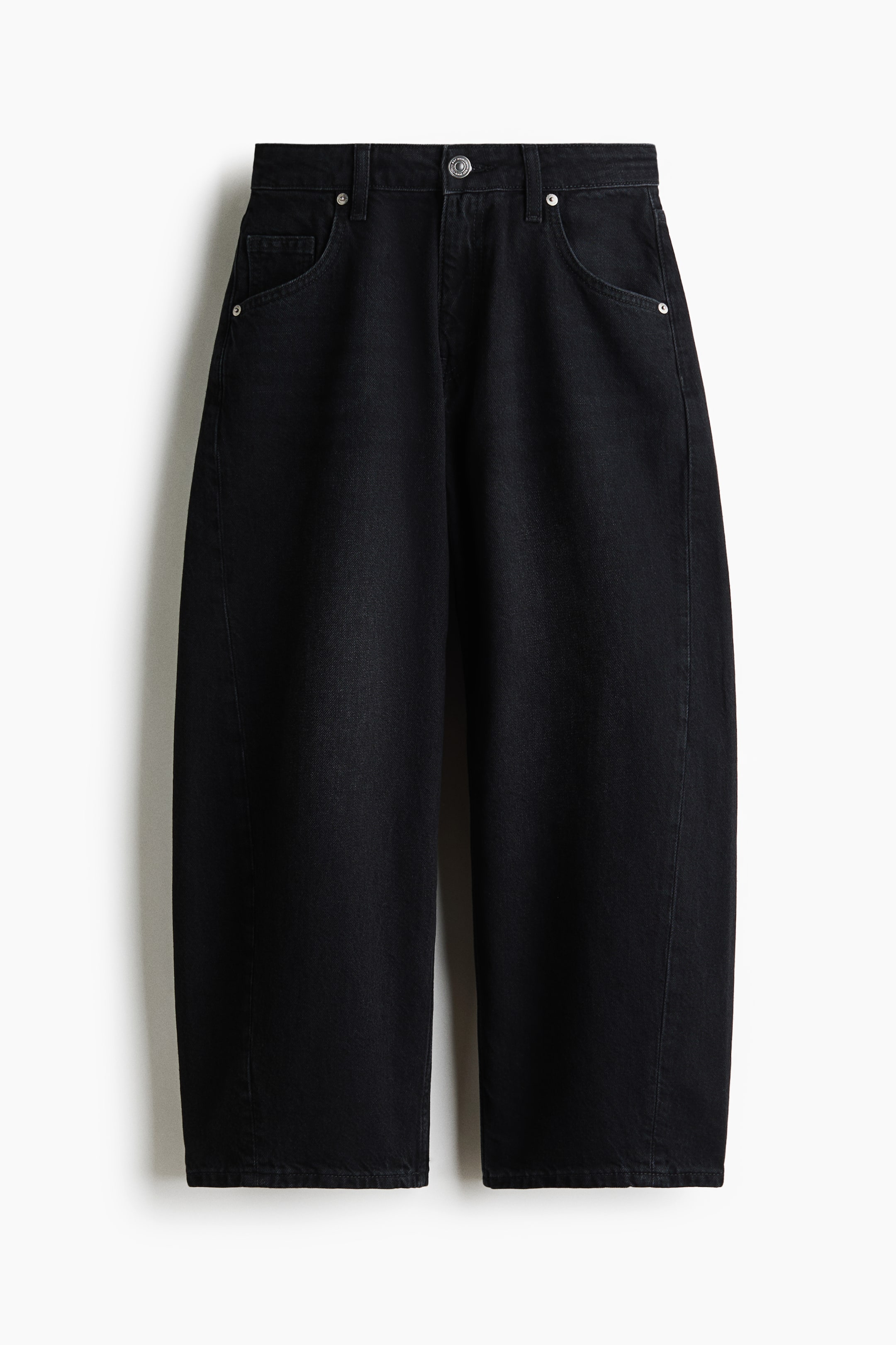 Grotere afbeelding bekijken: Zwarte katoenen denimjeans worden van voren gepresenteerd en hebben een hoge taille met een ritssluiting en een metalen knoopsluiting. De volumineuze pijpen lopen taps toe naar een enkellange zoom, en twee gebogen voorzakken met klinknagels zijn zichtbaar.