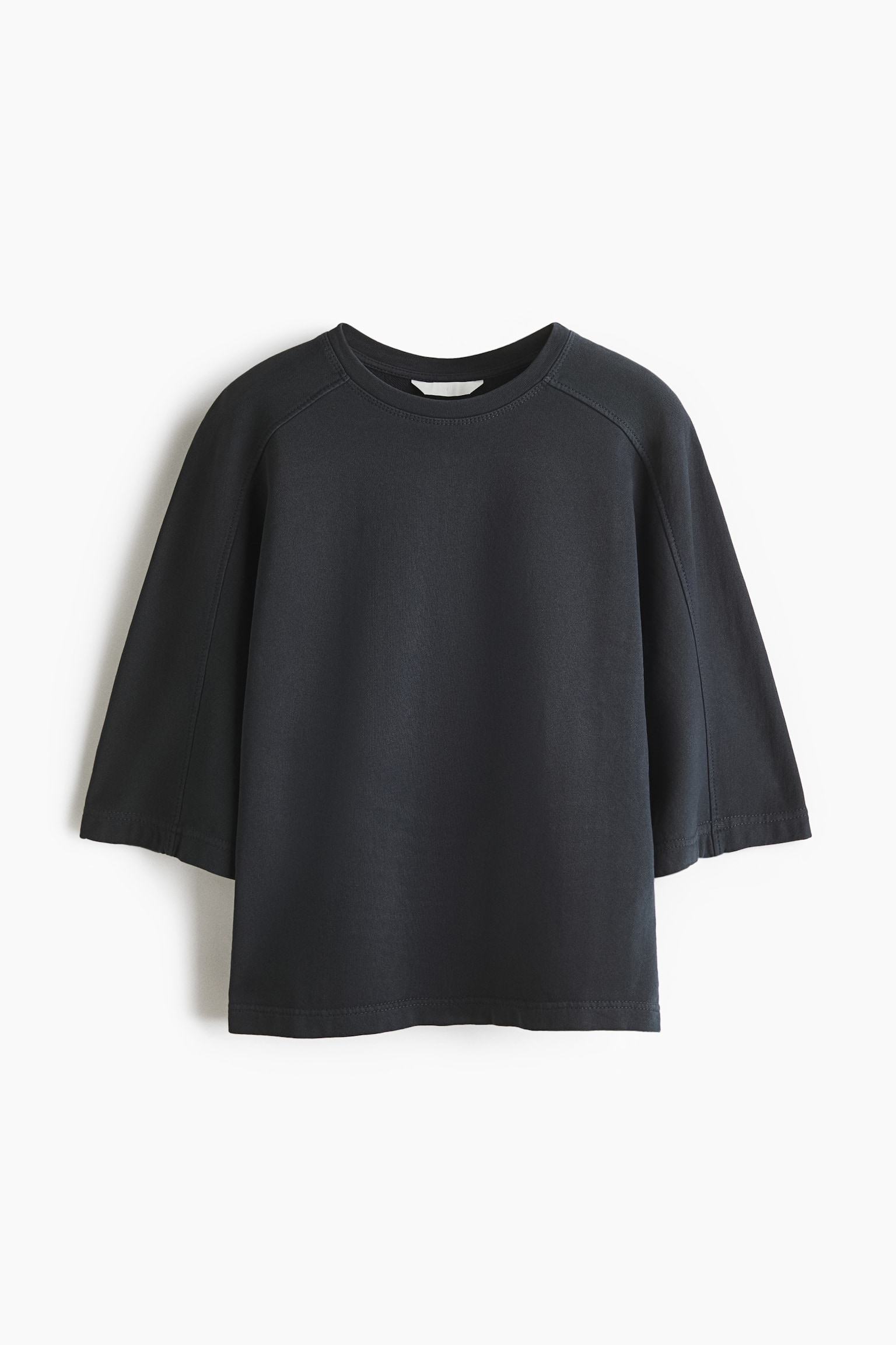 A dark grey, loose-fit top is facing front, revealing a round neckline and wide, 3/4-length saddle sleeves with visible seam detailing. It is showcasing a straight-cut hem and a smooth, lightweight cotton sweatshirt fabric.