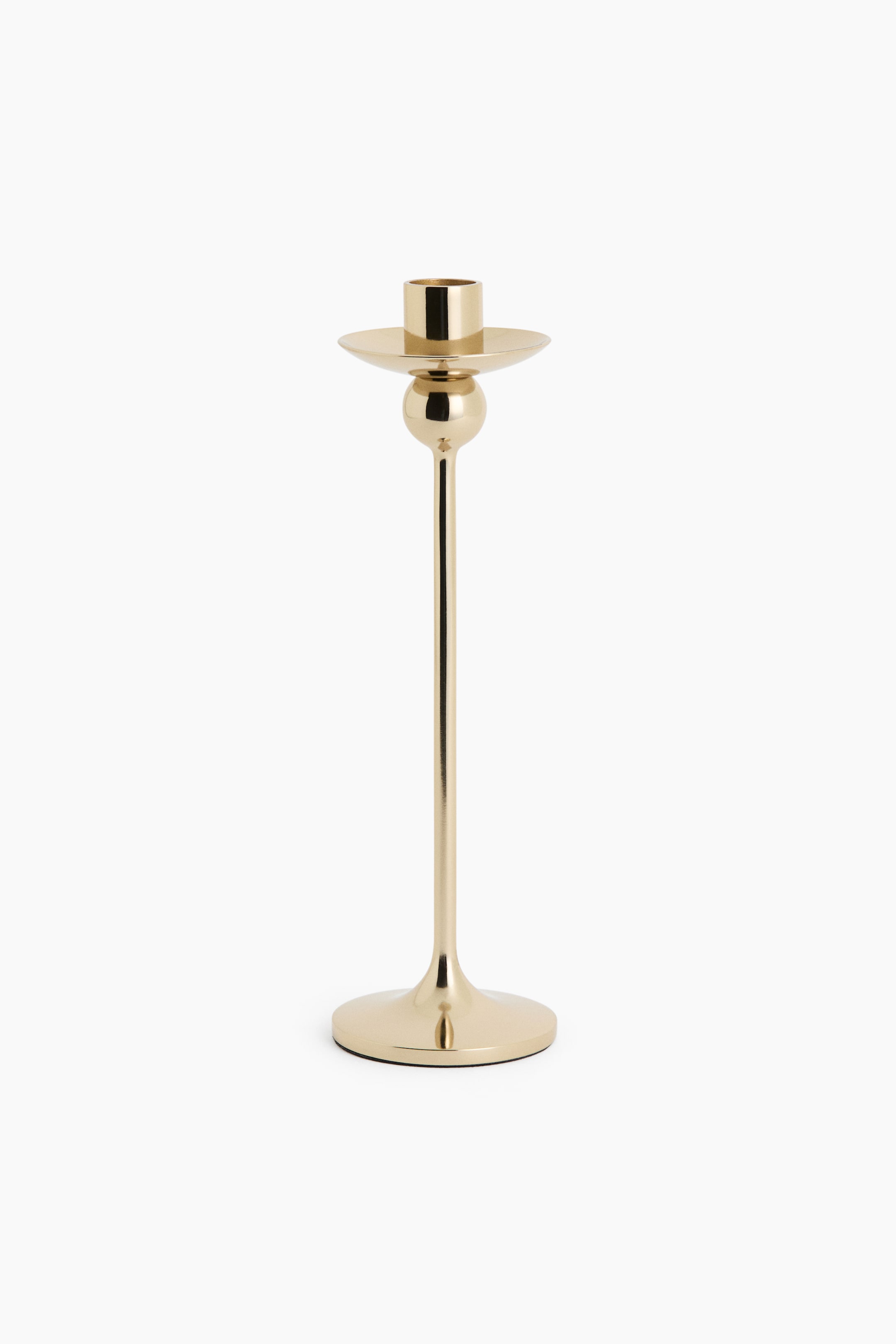 View larger image: A polished stainless steel candlestick with a gold finish stands upright, featuring a sleek, slender stem rising from a flared circular base. The design showcases a spherical detail positioned directly beneath a shallow drip tray and a cylindrical candle holder at the top.
