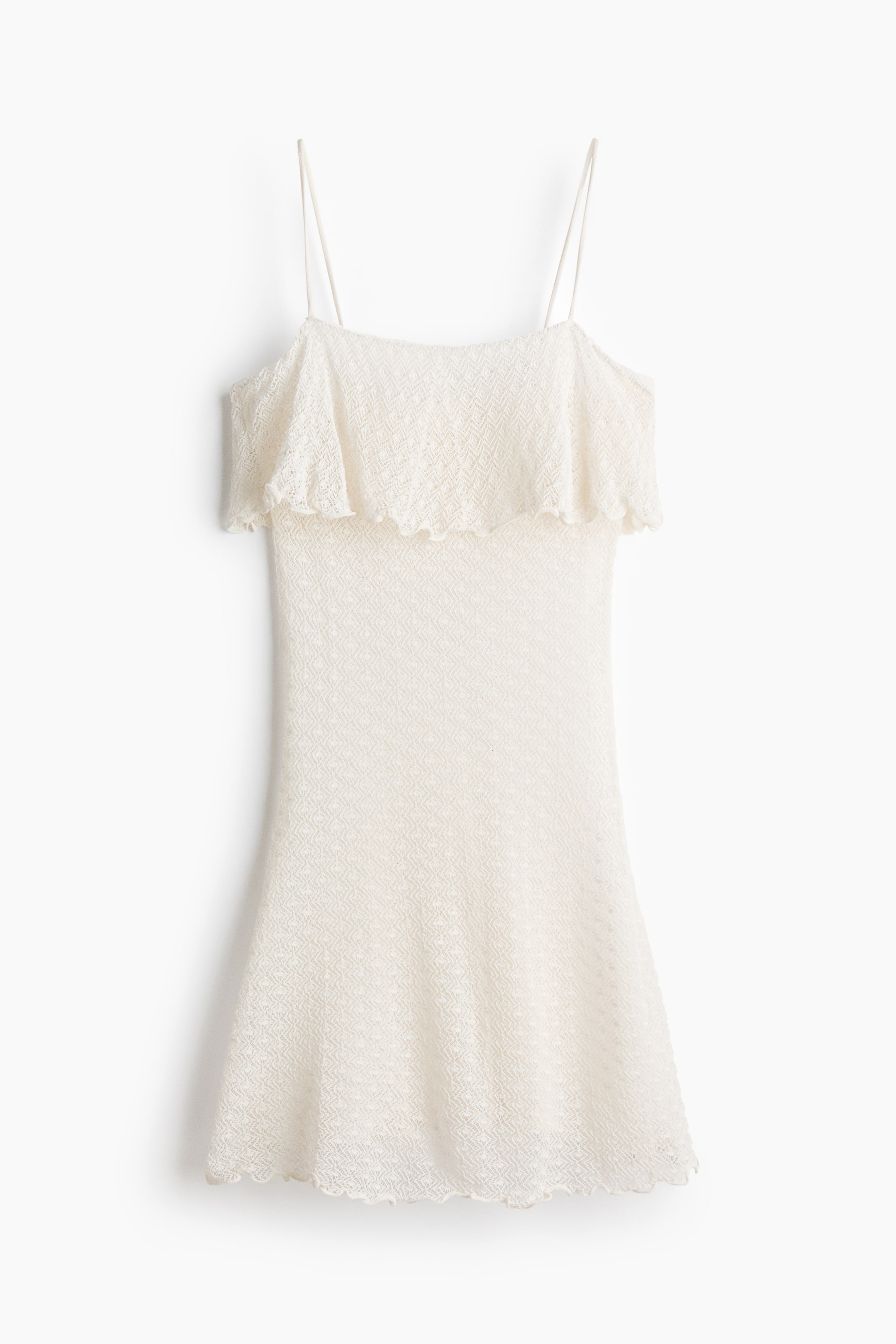 Ver imagen más grande: Vestido de punto color crema, VISTA FRONTAL, con finos tirantes tipo espagueti y un amplio volante en el busto con borde festoneado. El vestido presenta un sutil patrón geométrico a lo largo de su longitud y un dobladillo festoneado a juego.