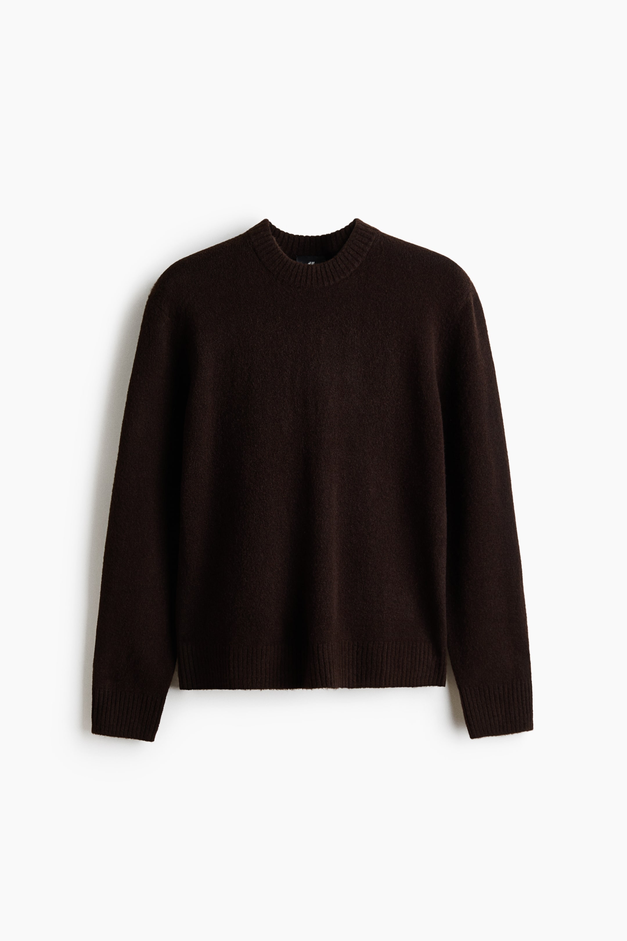 Agrandir l'image: Un pull marron foncé est présenté de face, avec une maille douce à finition brossée. Il est conçu avec un col rond à bord-côtes, ainsi que des poignets et un ourlet côtelés.