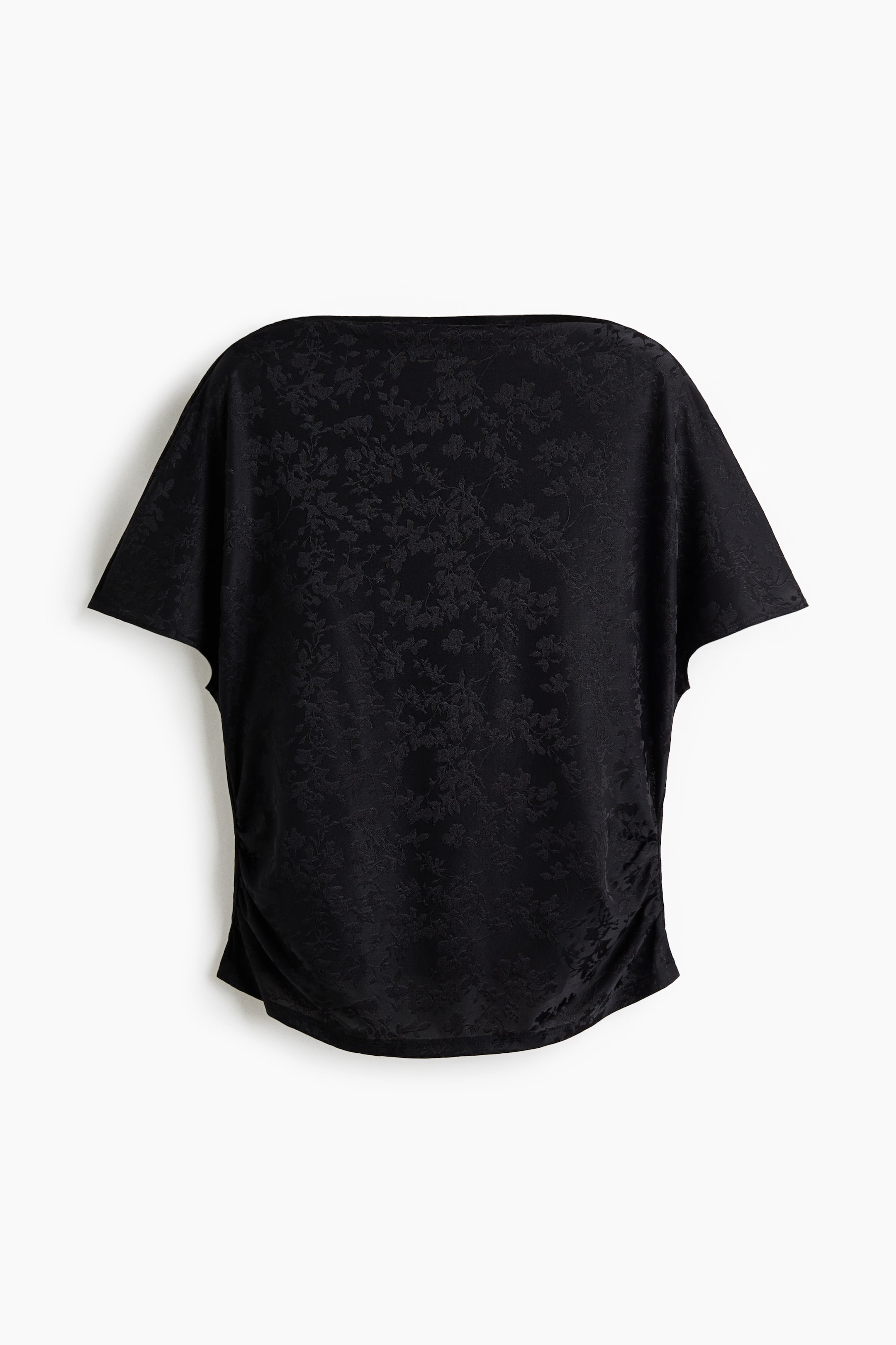 Xem ảnh lớn hơn: Chiếc áo jacquard đen này, chụp từ phía trước, có cổ thuyền rộng, tay dolman ngắn xếp rủ và họa tiết hoa tinh tế. Phần thân áo được nhấn bằng chi tiết nhún dọc theo đường may sườn bên phía dưới để tạo phom dáng rủ mềm mại.