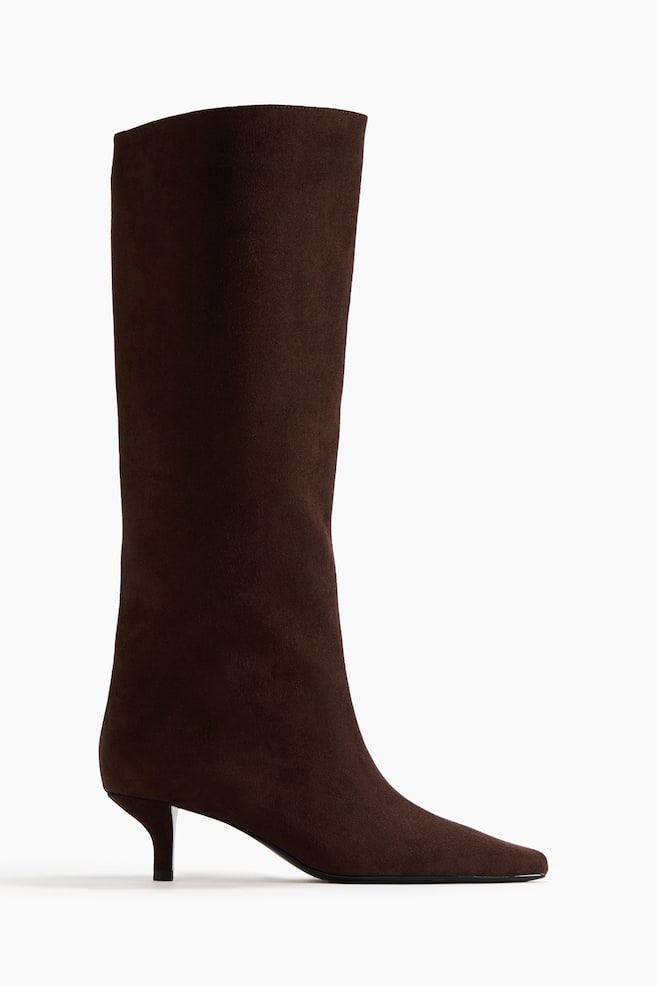 A dark brown suede boot showcasing a tall shaft, a pointed square toe, and a sleek kitten heel. - 1