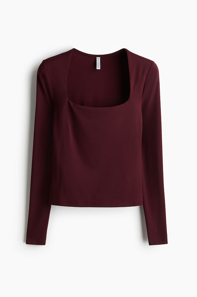 A burgundy long-sleeved top is presented from the front, featuring a deep square neckline and long sleeves, and is showing a smooth, fitted silhouette. - 1