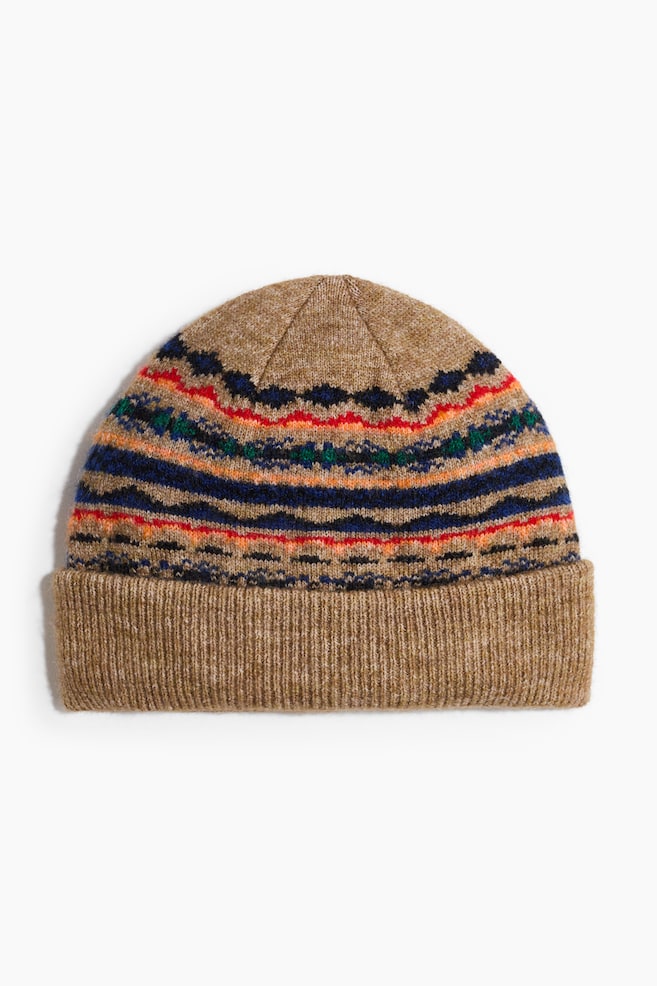 Eine gestrickte Beanie-MÃ¼tze in hellem melierten Braun ist von vorn zu sehen und zeigt ein horizontales Fair-Isle-Muster mit Streifen in Rot, Orange, Blau und GrÃ¼n. Die MÃ¼tze verfÃ¼gt Ã¼ber einen breiten, gerippten Umschlagbund in einheitlichem hellem Braun. - 1