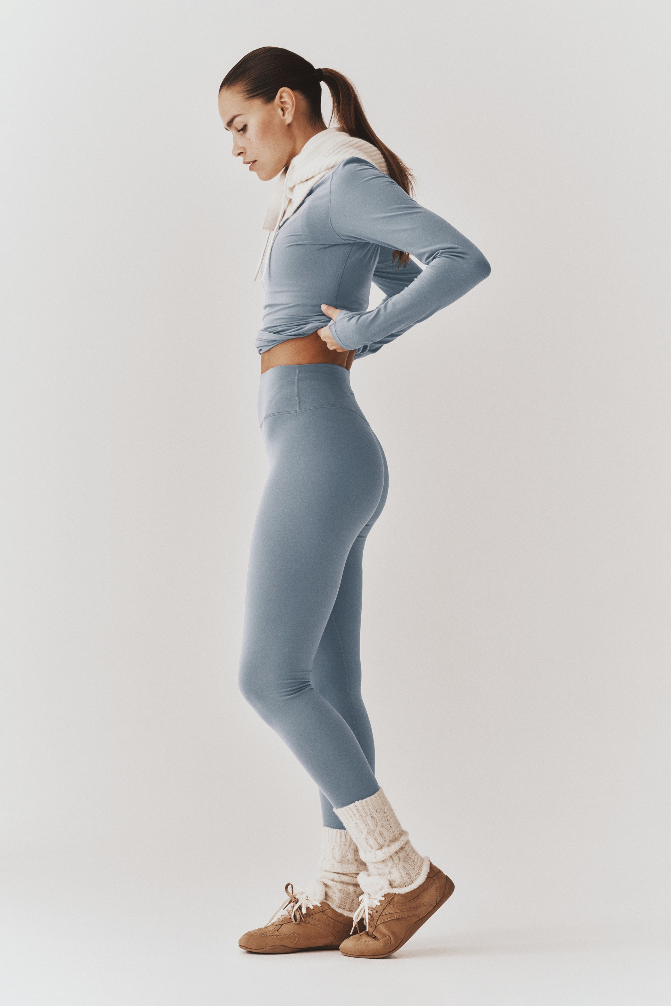 Ein Paar hellblaue High-Rise-Leggings wird in der Frontansicht gezeigt, mit einem breiten Bund und einer glatten, figurbetonten Silhouette, die zu den Knöcheln hin schmal zuläuft.