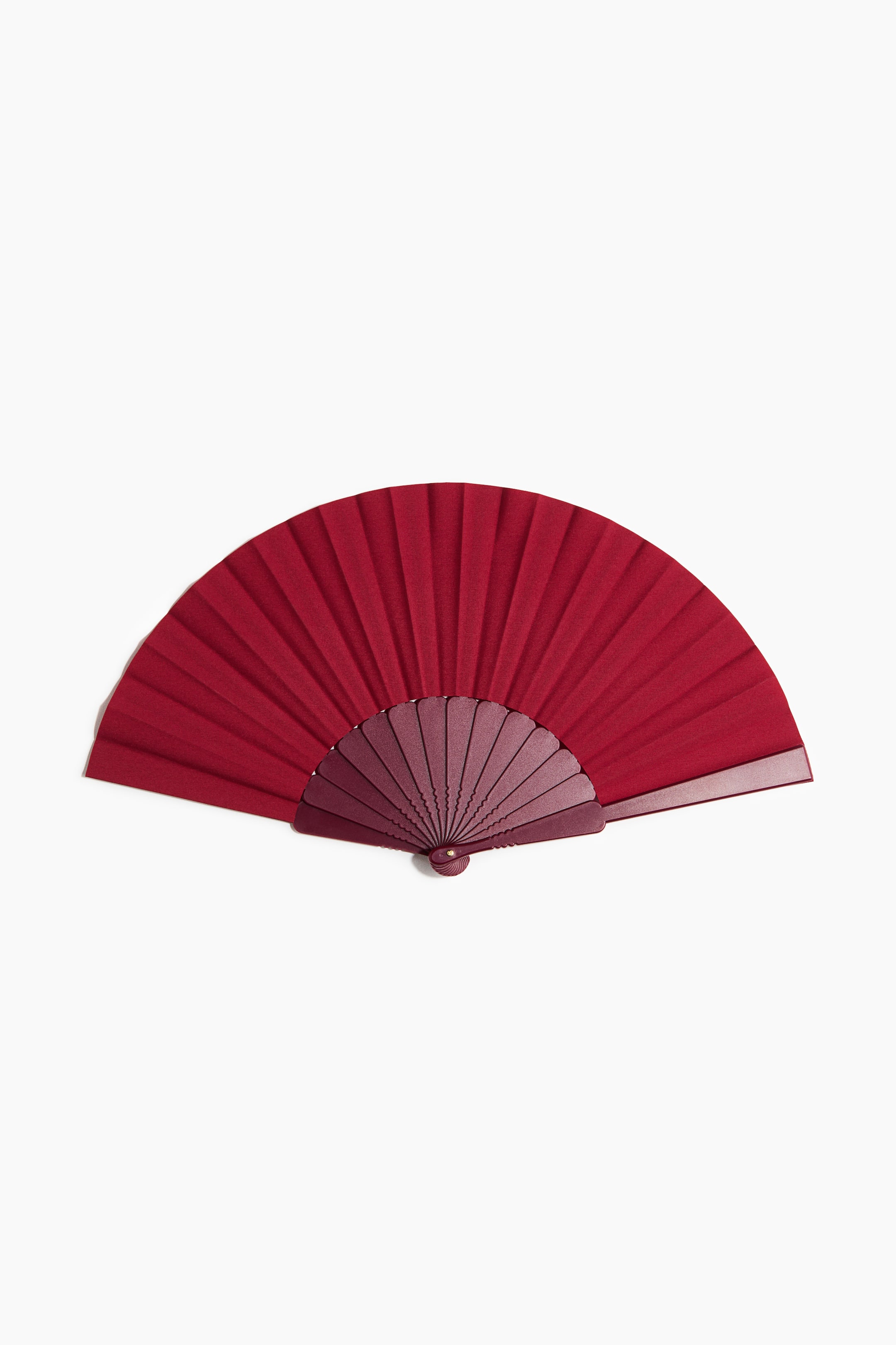 Agrandir l'image: Un éventail pliant présente son tissu plissé rouge foncé, s'épanouissant à partir de côtes en plastique rouge plus foncé. Un rivet en métal fixe les côtes à la base.
