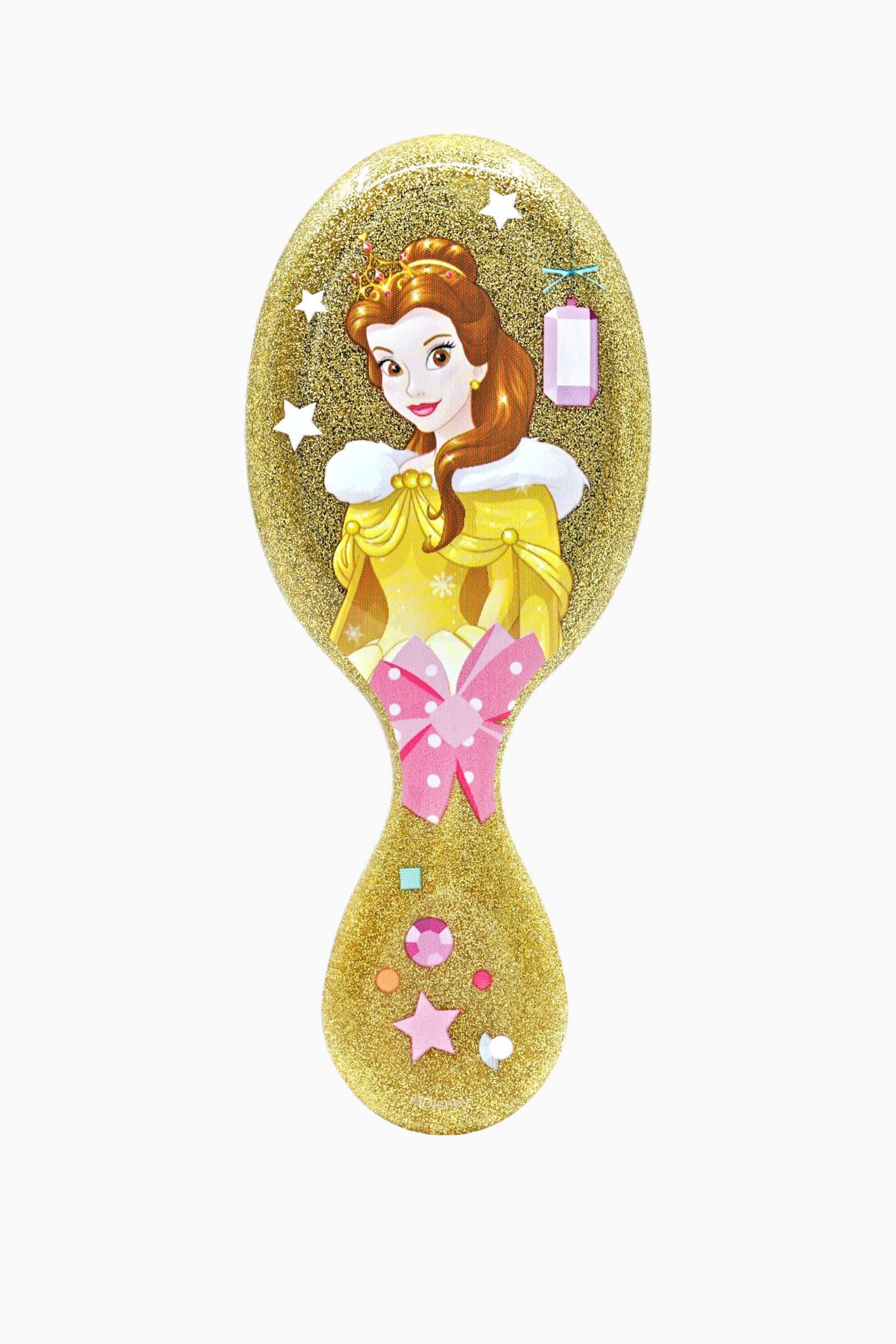 Se større billede: En gylden glitterhårbørste med pagajform har en illustration af Belle fra Skønheden og Udyret på børstehovedet, iført en gul kjole med hvid pelskant og en krone, omgivet af hvide stjerner og en lilla lanterne. Børstens håndtag er dekoreret med en lyserød sløjfe med prikker, en lyserød stjerne og forskellige farverige smykkelignende pyntedetaljer.