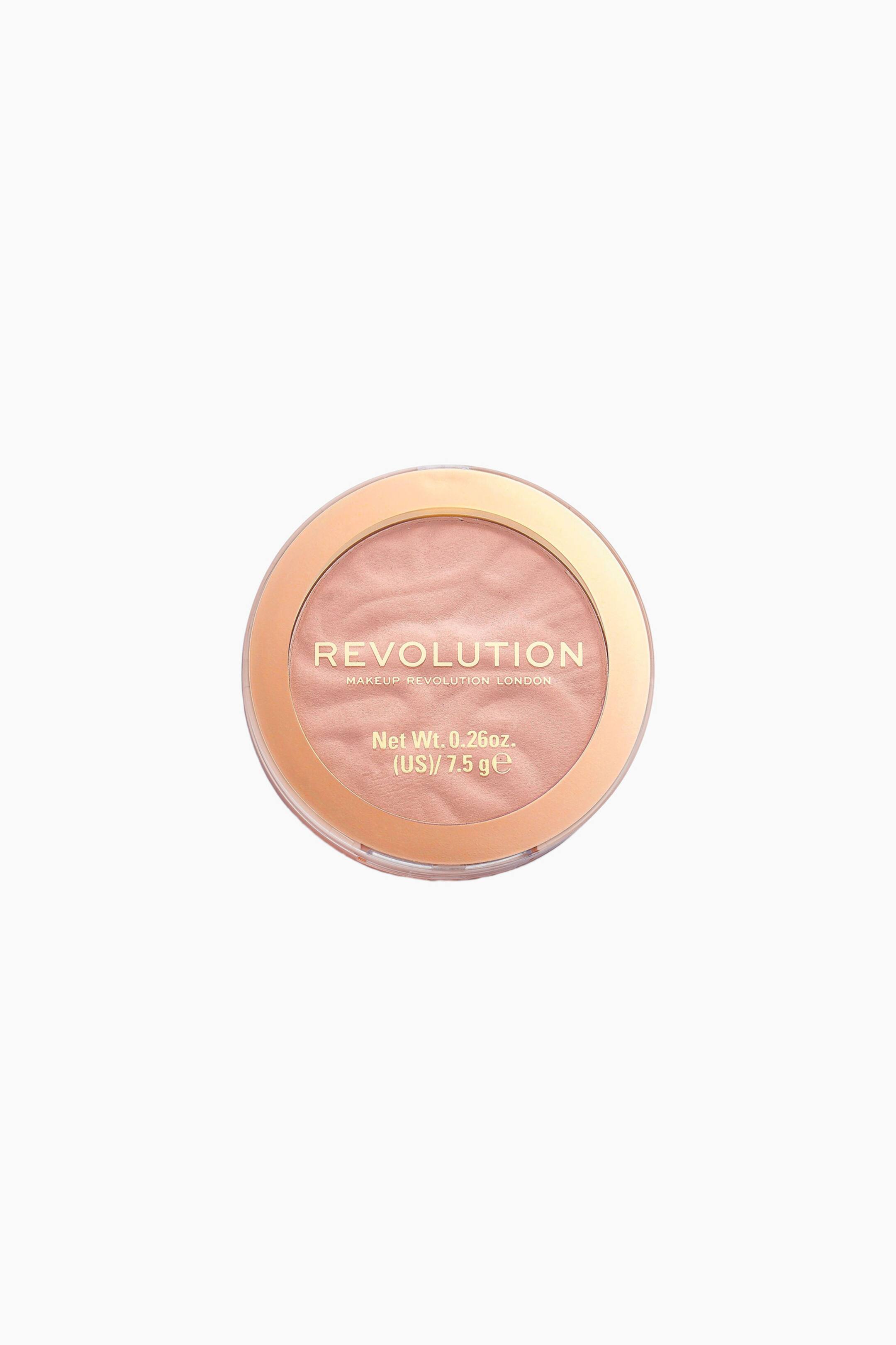 Größeres Bild ansehen: Ein rundes Revolution-Make-up-Compact wird aus der Draufsicht gezeigt und verfügt über einen schimmernden, pfirsichfarbenen Puder mit einer wellenförmigen, strukturierten Oberfläche. Der transparente Deckel zeigt einen metallisch roségoldenen Rand sowie goldene Markenbeschriftung.