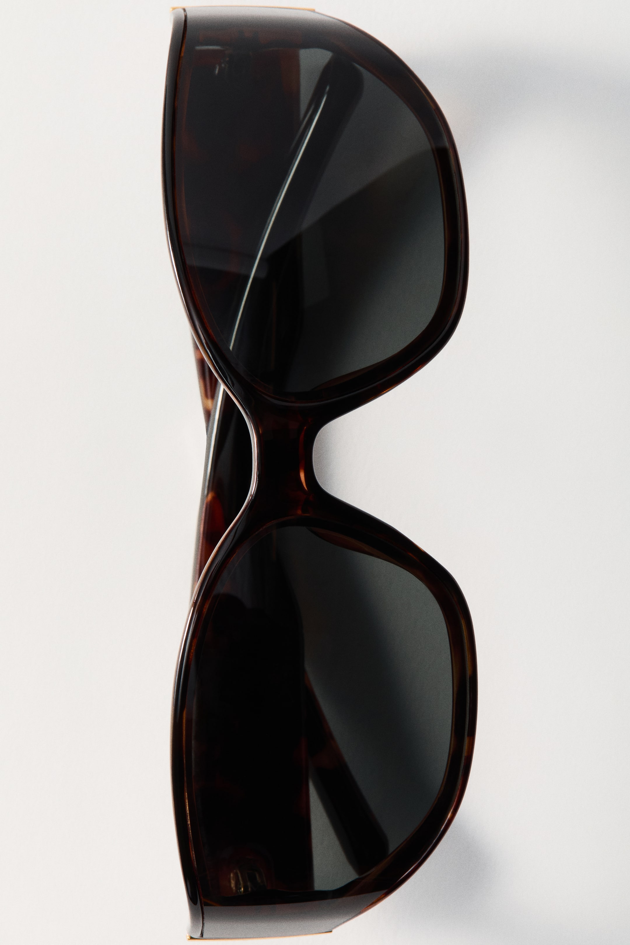 View larger image: Visor sunglasses feature large, rounded tortoiseshell plastic frames and dark-tinted lenses. They are positioned facing forward at a slight angle.