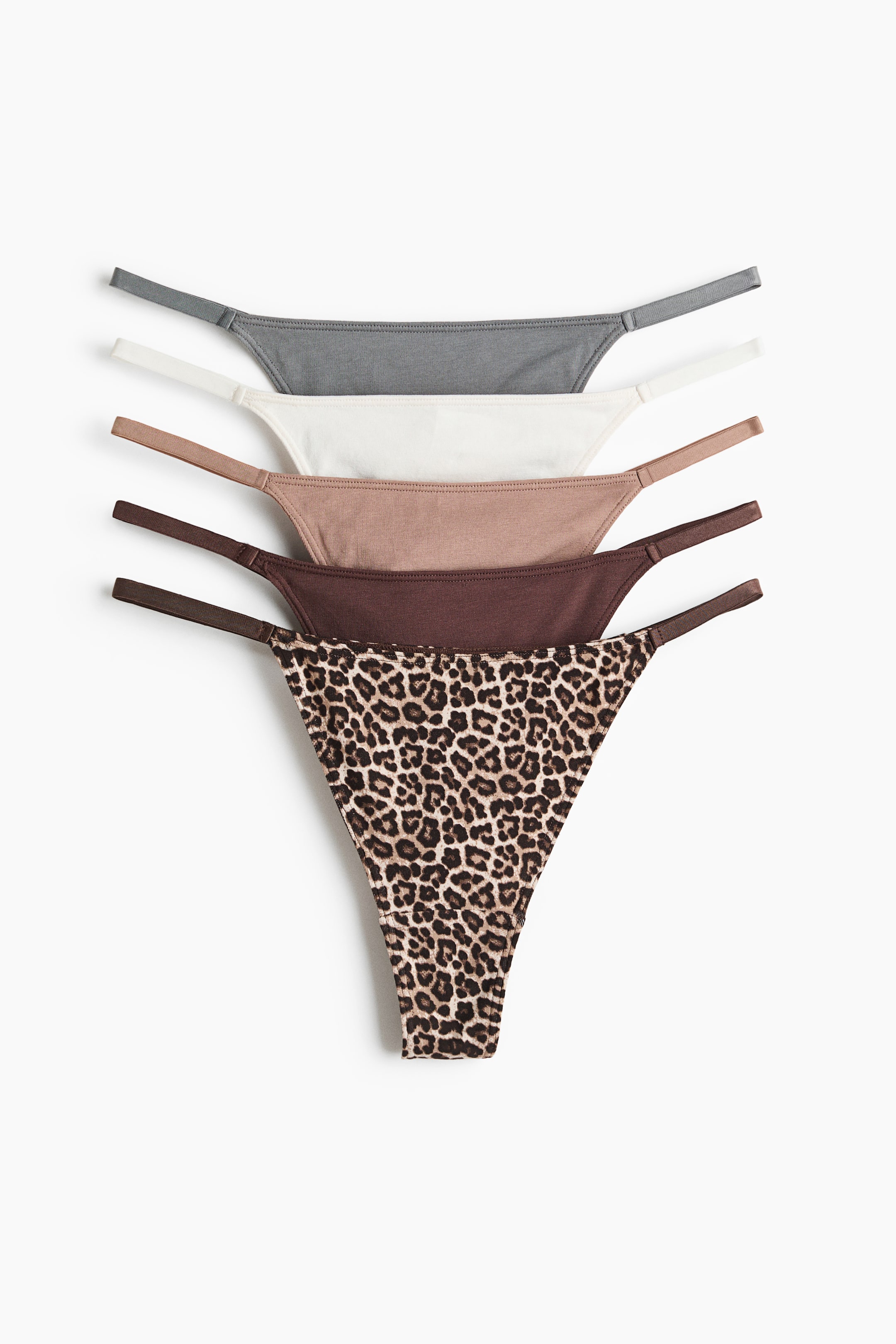 View larger image: Five thong briefs made from organic cotton jersey are showcased in a stacked arrangement, all facing forward. They feature a low-rise waist, lined gusset, and narrow sides. The color options include gray, white, light brown, dark brown, and a leopard print.