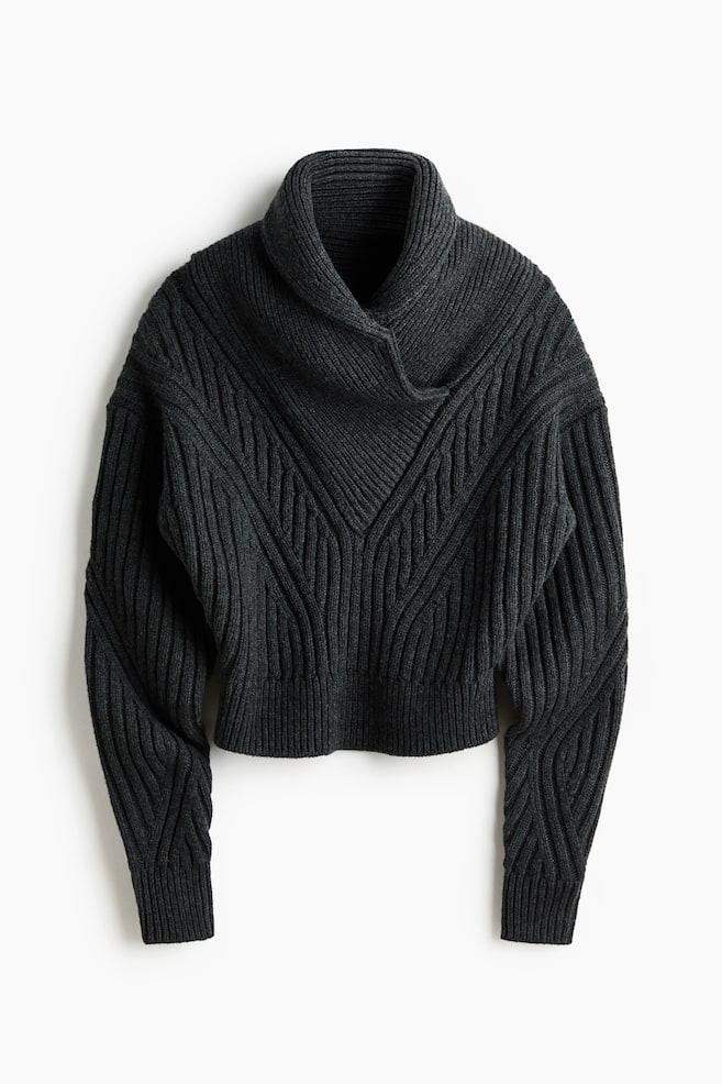The dark gray knit sweater is featuring a wide, folded cowl neck and a prominent V-shaped ribbed pattern across its front. It is displaying long sleeves with diagonal ribbed designs, ribbed cuffs, and a ribbed hem. - 1