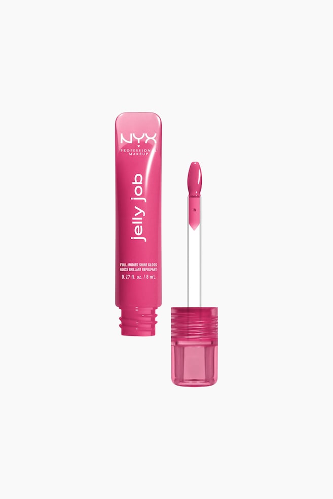 Et klart pink lipglossrør står oprejst og viser hvid tekst på siden, herunder "NYX PROFESSIONAL MAKEUP", "jelly job", "FULL-BODIED SHINE GLOSS" og "0.27 fl. oz. / 8 mL". Hætten er fjernet, og applikatoren, med en klar stilk og en padleformet pink spids, rækker ud mod højre. - 1