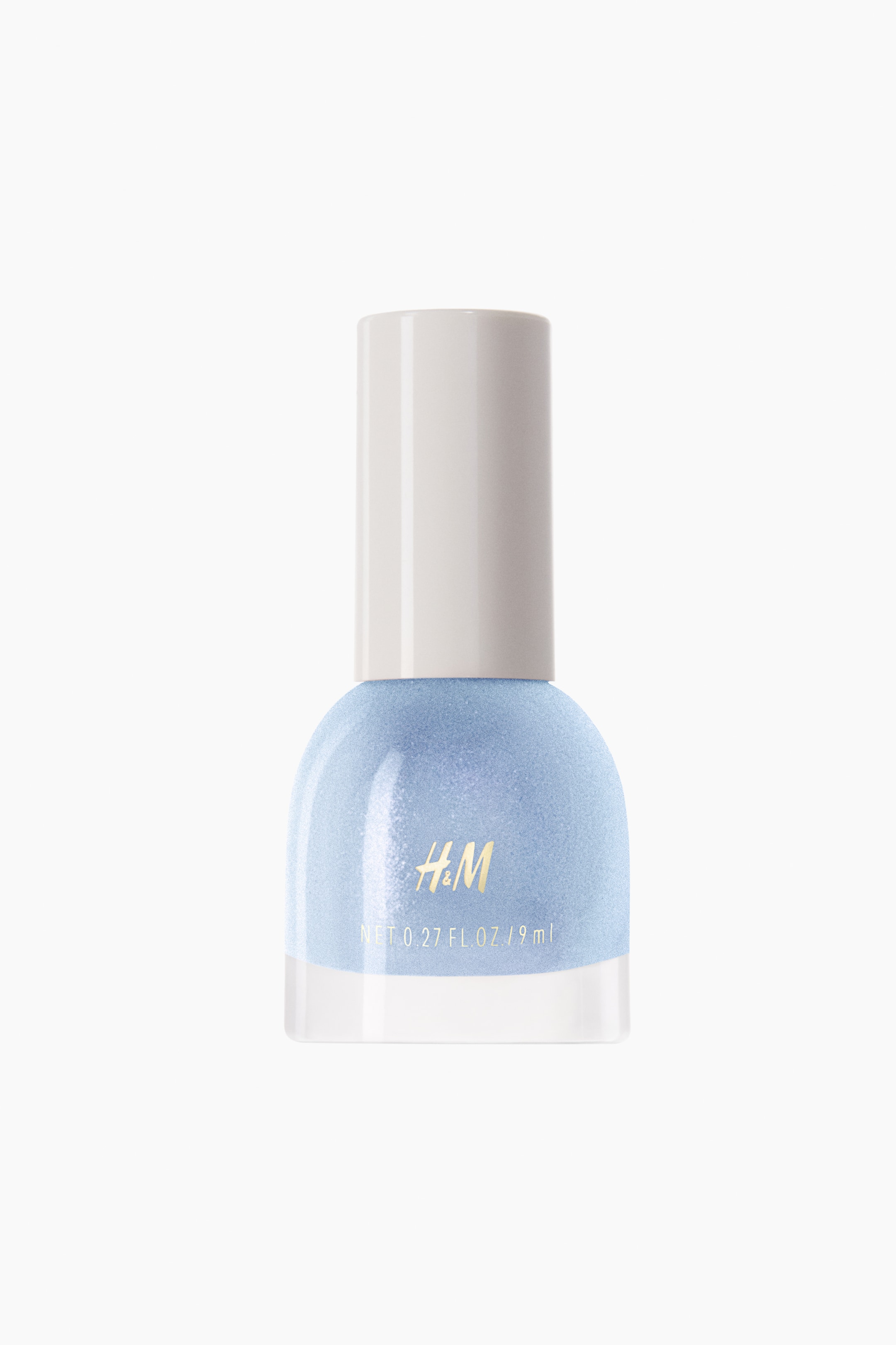 View larger image: The nail polish comes in a transparent glass bottle, containing a light blue, shimmery polish. It is topped with a white cylindrical cap that showcases the gold "H&M" branding and volume details on the front.
