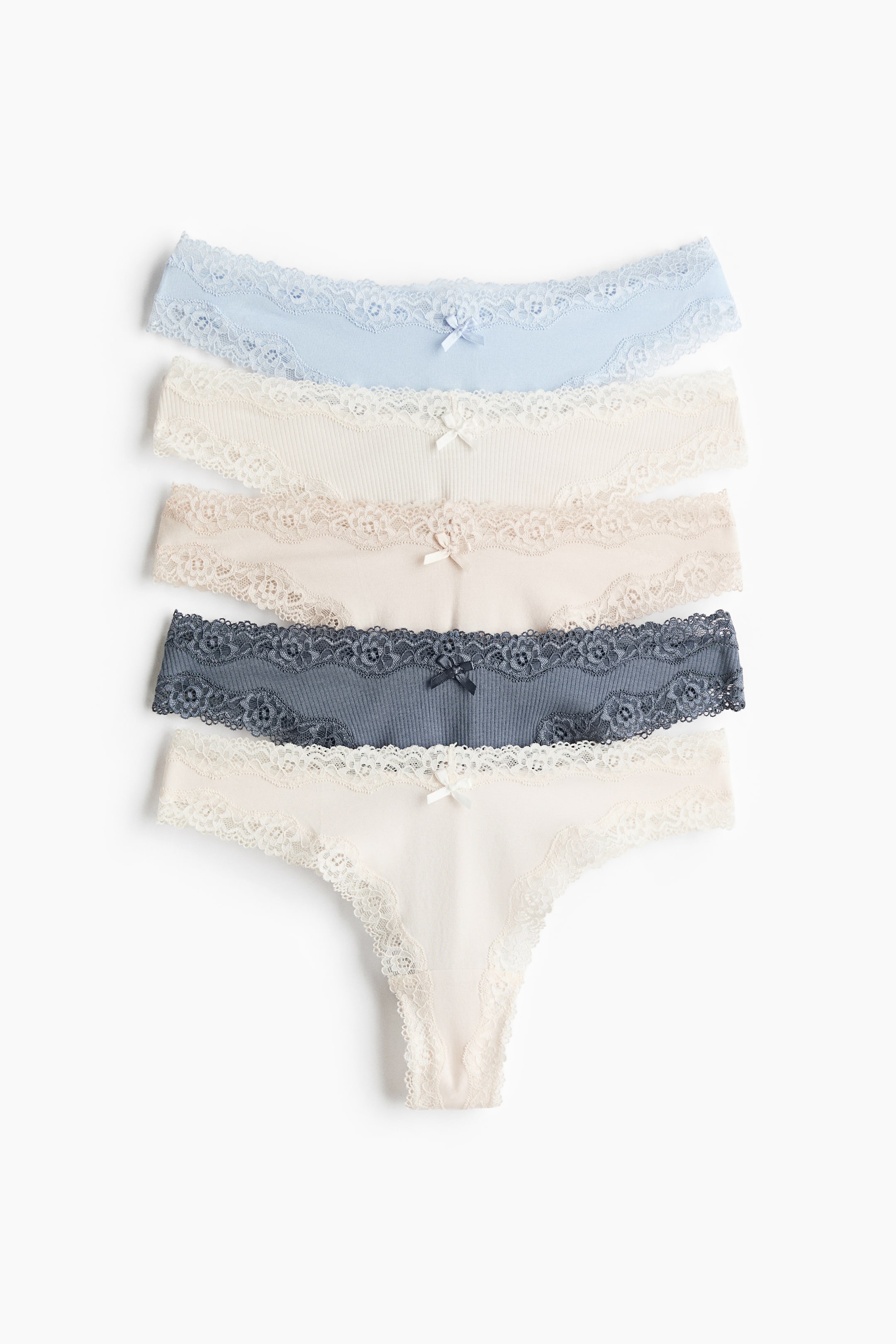 View larger image: Five pairs of briefs are displayed, fanned out to showcase their front design. Each pair features a mid-rise, V-shaped waist crafted from cotton jersey, accented with lace trim along the waistband and leg openings. They come in a variety of colors, including light blue, off-white, light beige, dark gray, and cream. Each brief is decorated with a small bow at the center front of the waistband.