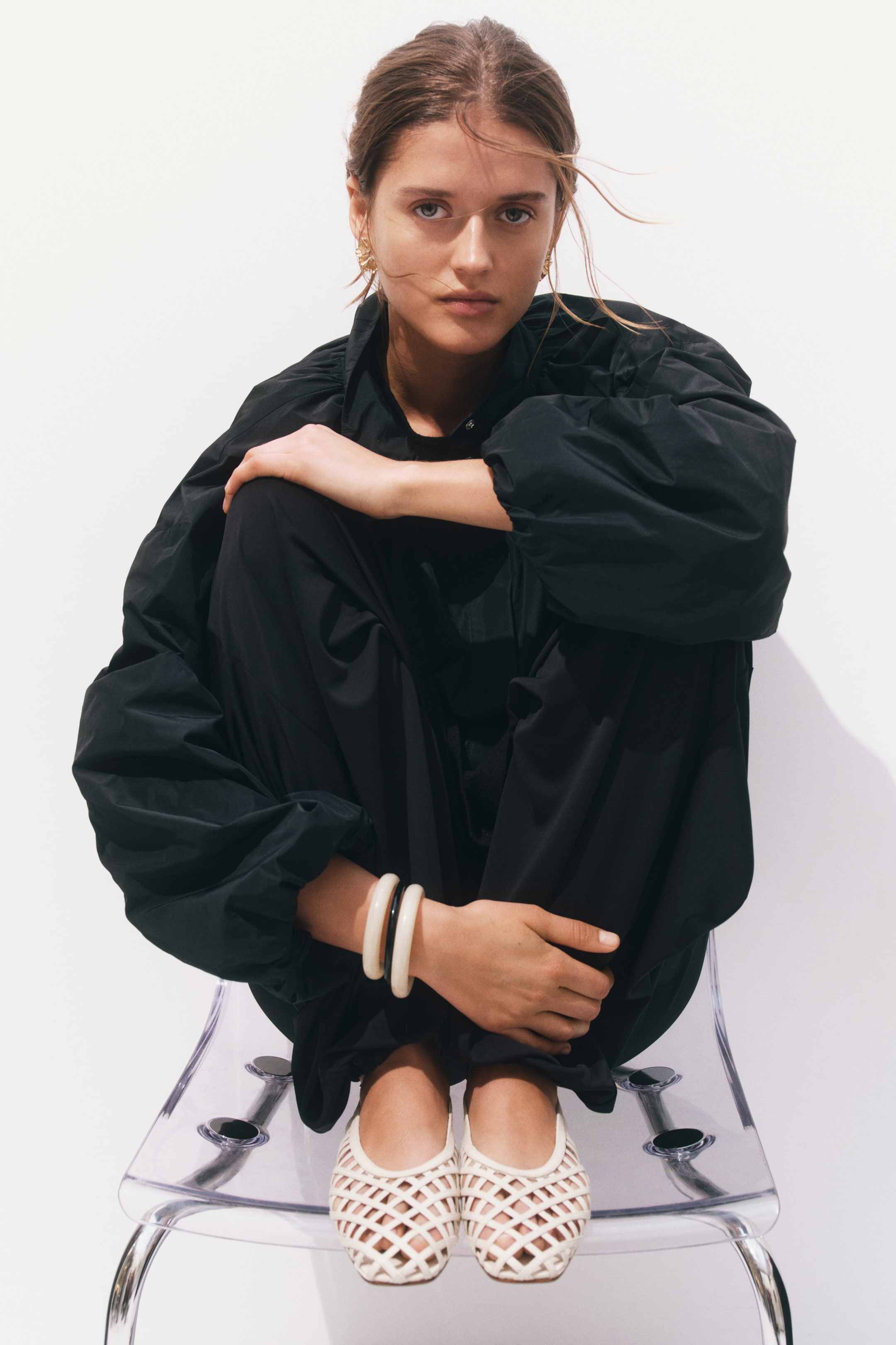 View larger image: A black oversized jacket featuring voluminous sleeves with elasticated cuffs and a stand collar.