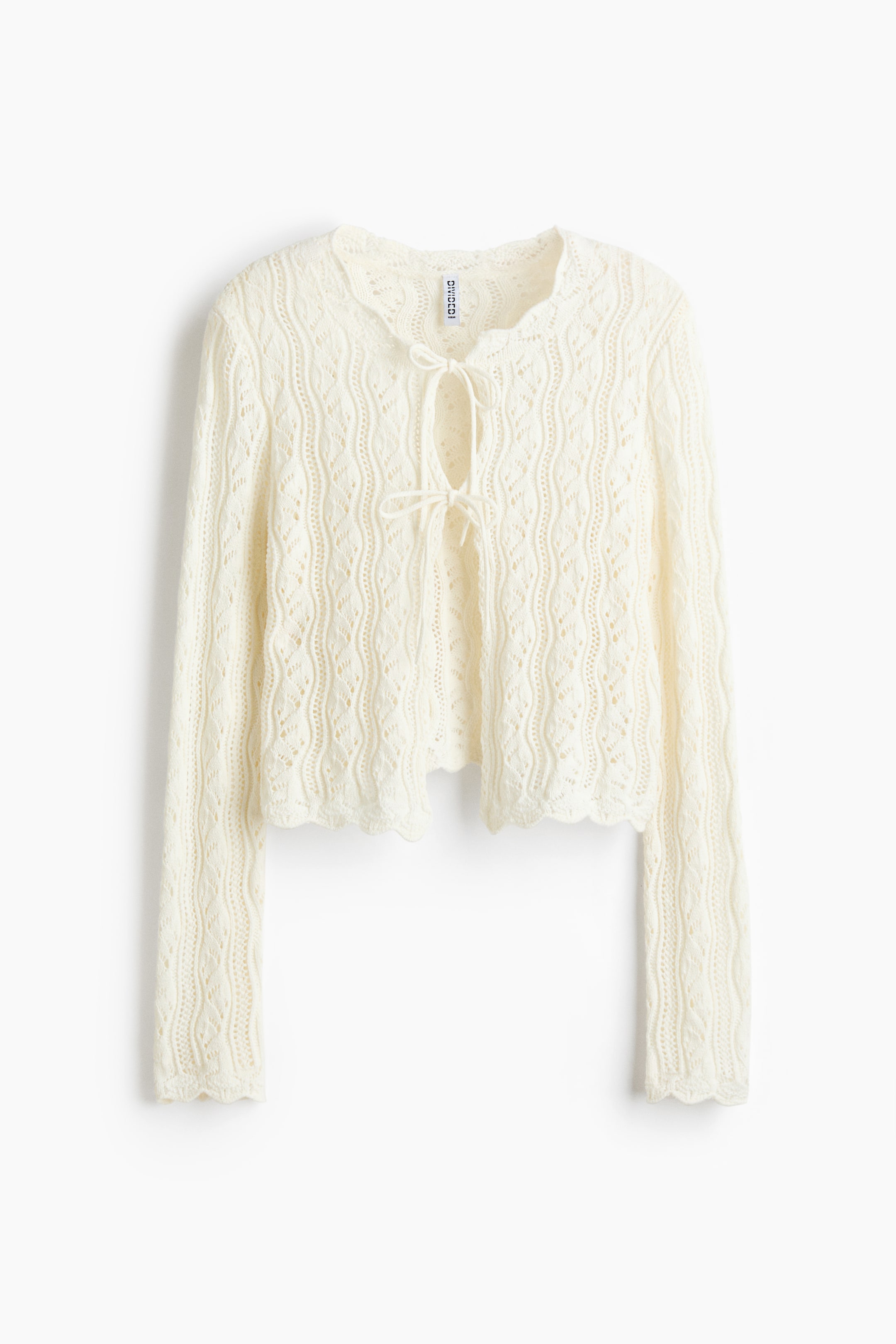 Größeres Bild anzeigen: Ein cremefarbener Strick-Cardigan präsentiert sich VON VORNE, mit einer kurzen Länge und langen Ärmeln. Er zeigt ein aufwendiges Lochmuster im gesamten Design, mit gewellten Kanten am Saum und an den Bündchen sowie einem Bindeband am runden Ausschnitt.