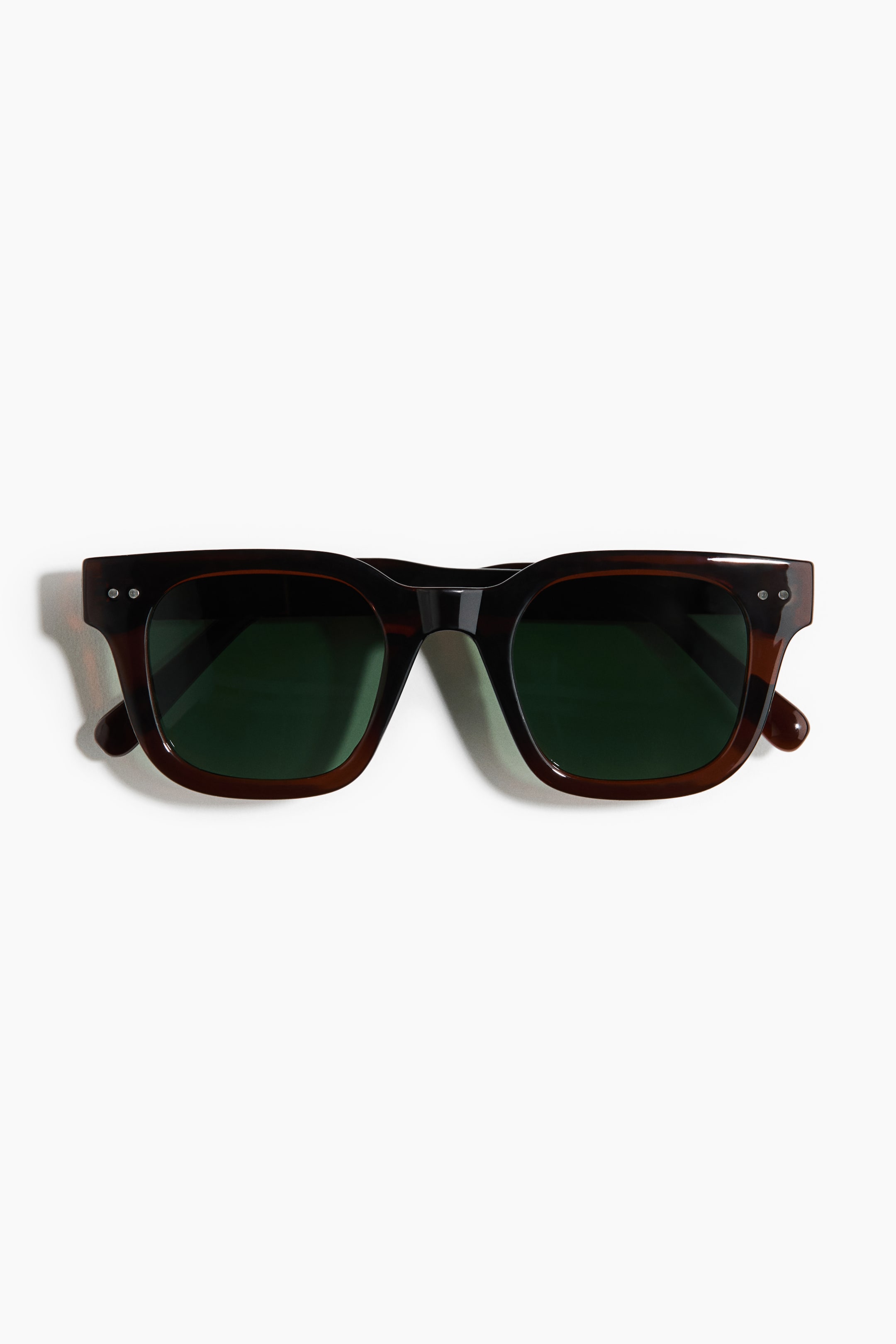 View larger image: The sunglasses feature a dark brown tortoiseshell frame with dark green lenses, shown from the front. Two small silver rivets are visible on the outer corners of the frame.