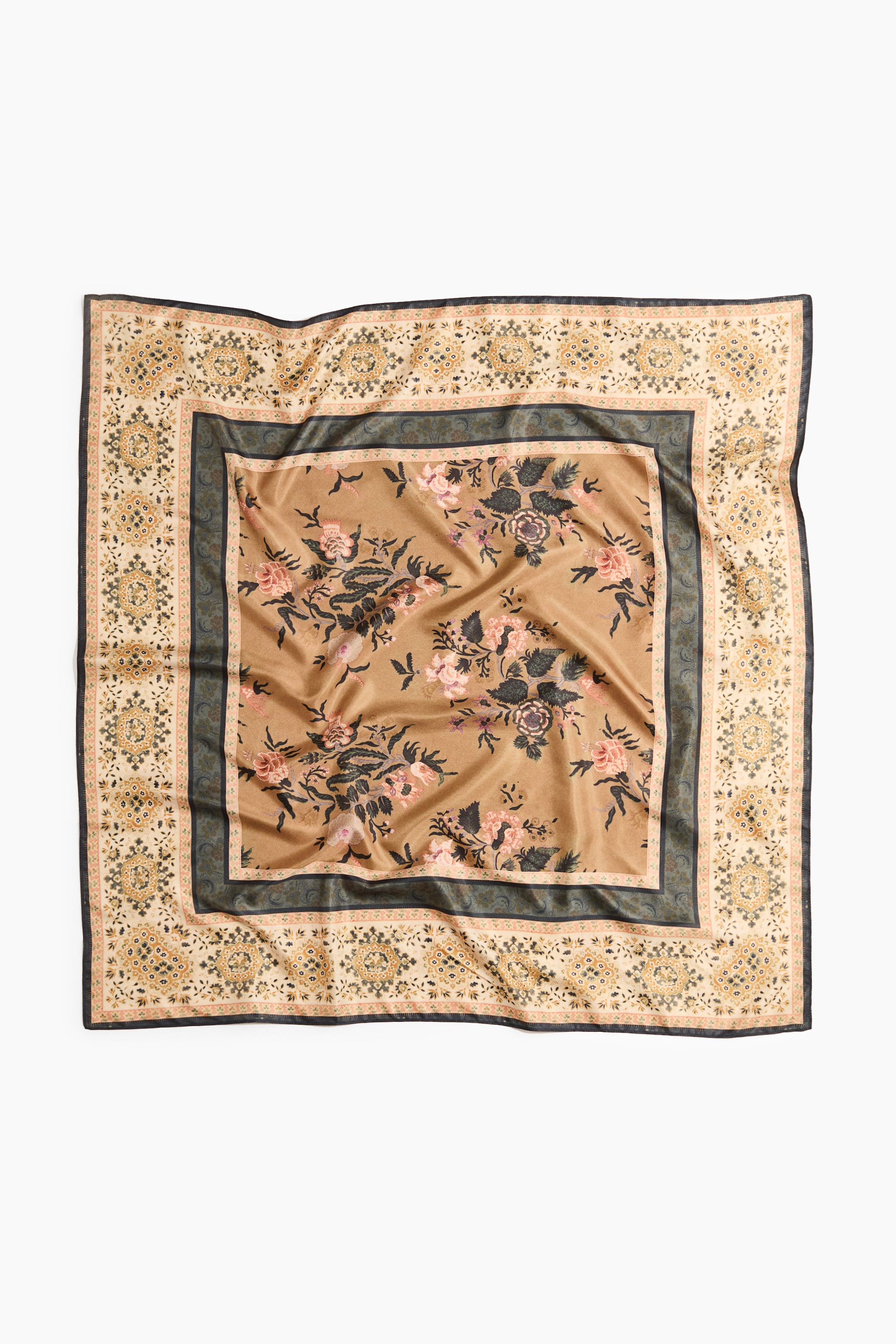 Größeres Bild ansehen: Ein Schal in weicher Webart mit bedrucktem Muster liegt flach und ist von vorne zu sehen. Er zeigt eine sandfarbene Mitte mit floralen Motiven in Rosa und Dunkelgrün, umrahmt von einem dunkelgrünen Band und einem äußeren hellbeigen Band mit einem filigranen Medaillonmuster.