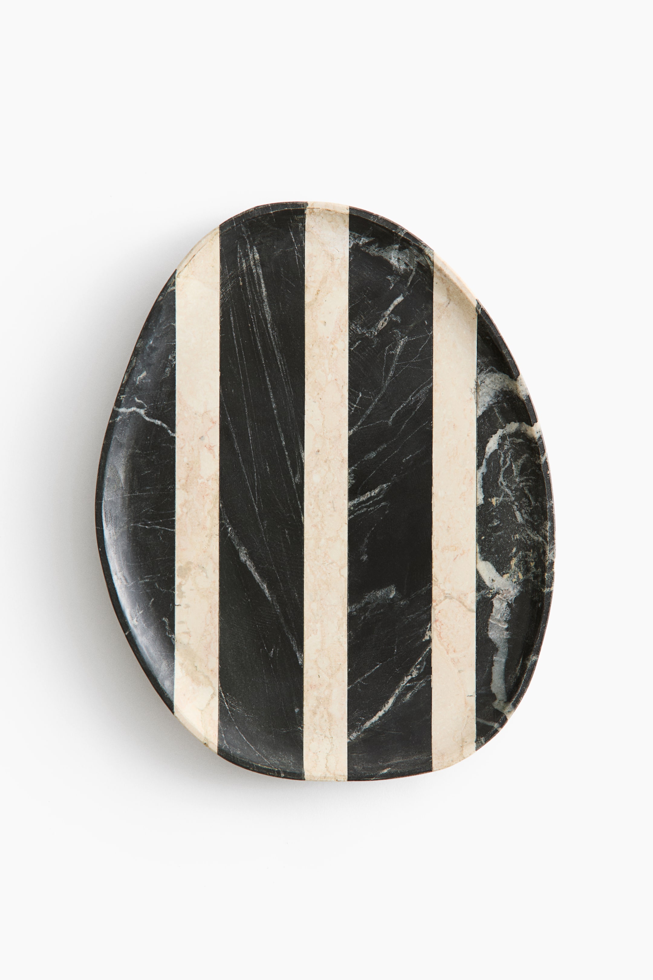 View larger image: An irregular oval marble plate showcases five vertical stripes, alternating between black and off-white hues. Natural veining is visible throughout the stone, viewed from directly above.