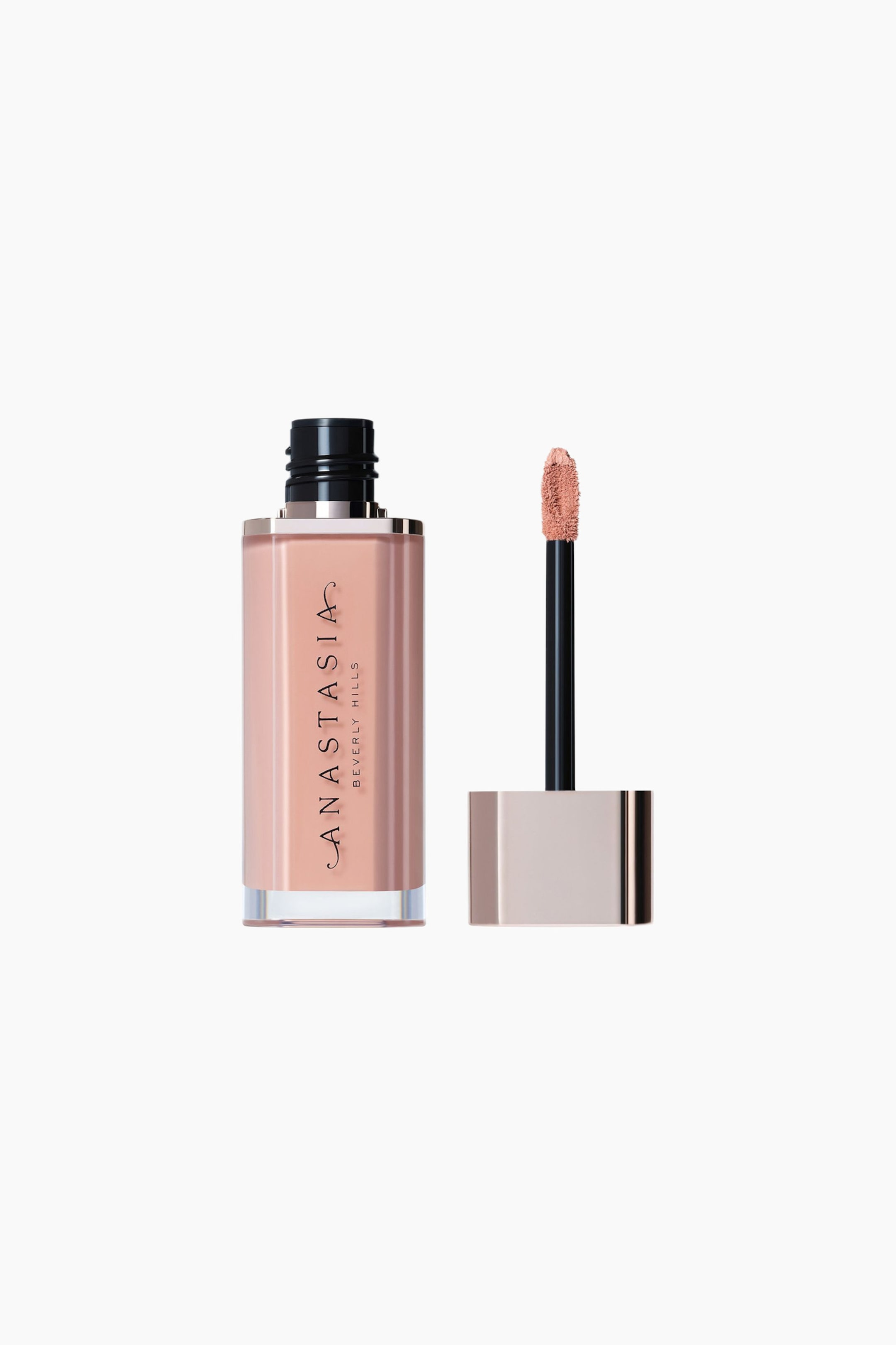 Vis større bilde: En rektangulær, gjennomsiktig glassflaske inneholder en ferskentonet væske og har en svart riflet kork, med merkenavnet «ANASTASIA BEVERLY HILLS» trykt vertikalt på siden. En separat applikator står ved siden av, med en svart stav, en metallisk base i roségull og en doe-foot-spiss med flocking, belagt med den samme ferskentonede væsken.