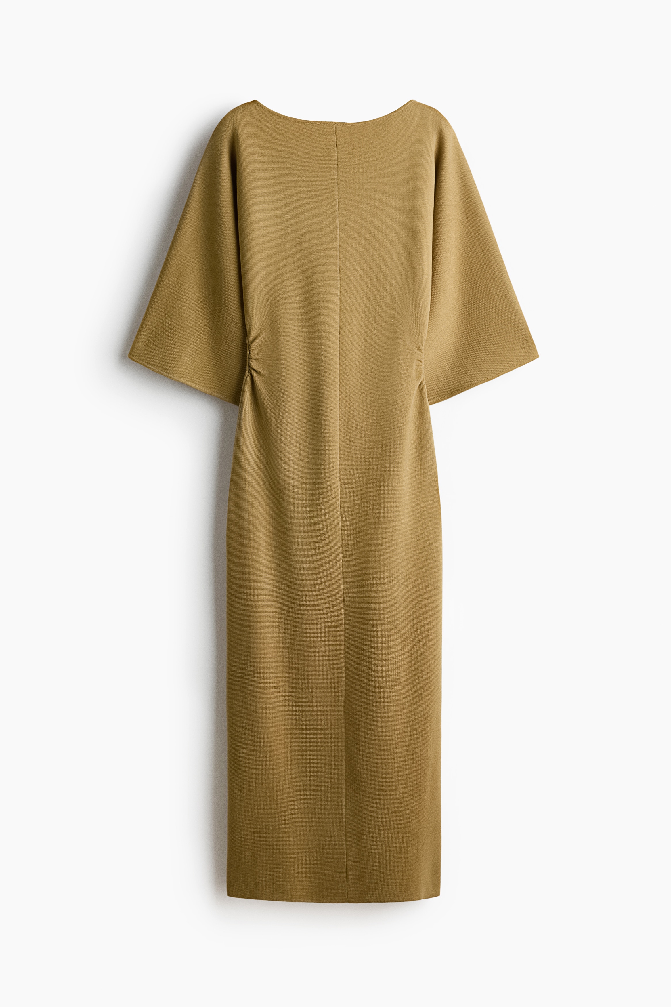A calf-length fitted knit dress in a light olive-yellow colour is being worn by the model, featuring a delicate boat neckline and wide batwing sleeves. The garment is styled with a visible centre seam down the front and gathered side seams that create a draped effect at the waist.