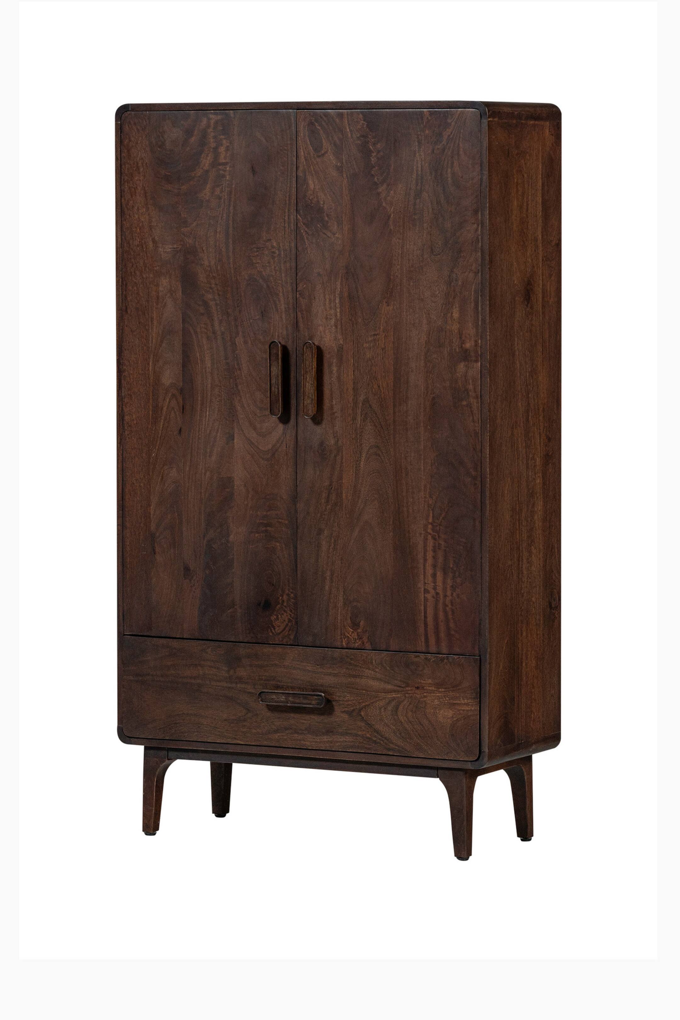 Größeres Bild ansehen: Ein dunkler Holzkleiderschrank mit ausgeprägter Holzmaserung steht in einem leichten Winkel, sodass seine Vorder- und rechte Seite sichtbar sind. Er verfügt über abgerundete obere und seitliche Kanten, zwei obere Türen mit vertikalen dunklen Metallgriffleisten und eine untere Schublade mit einer horizontalen dunklen Metallgriffleiste, die alle auf vier ausgestellten Beinen ruhen.