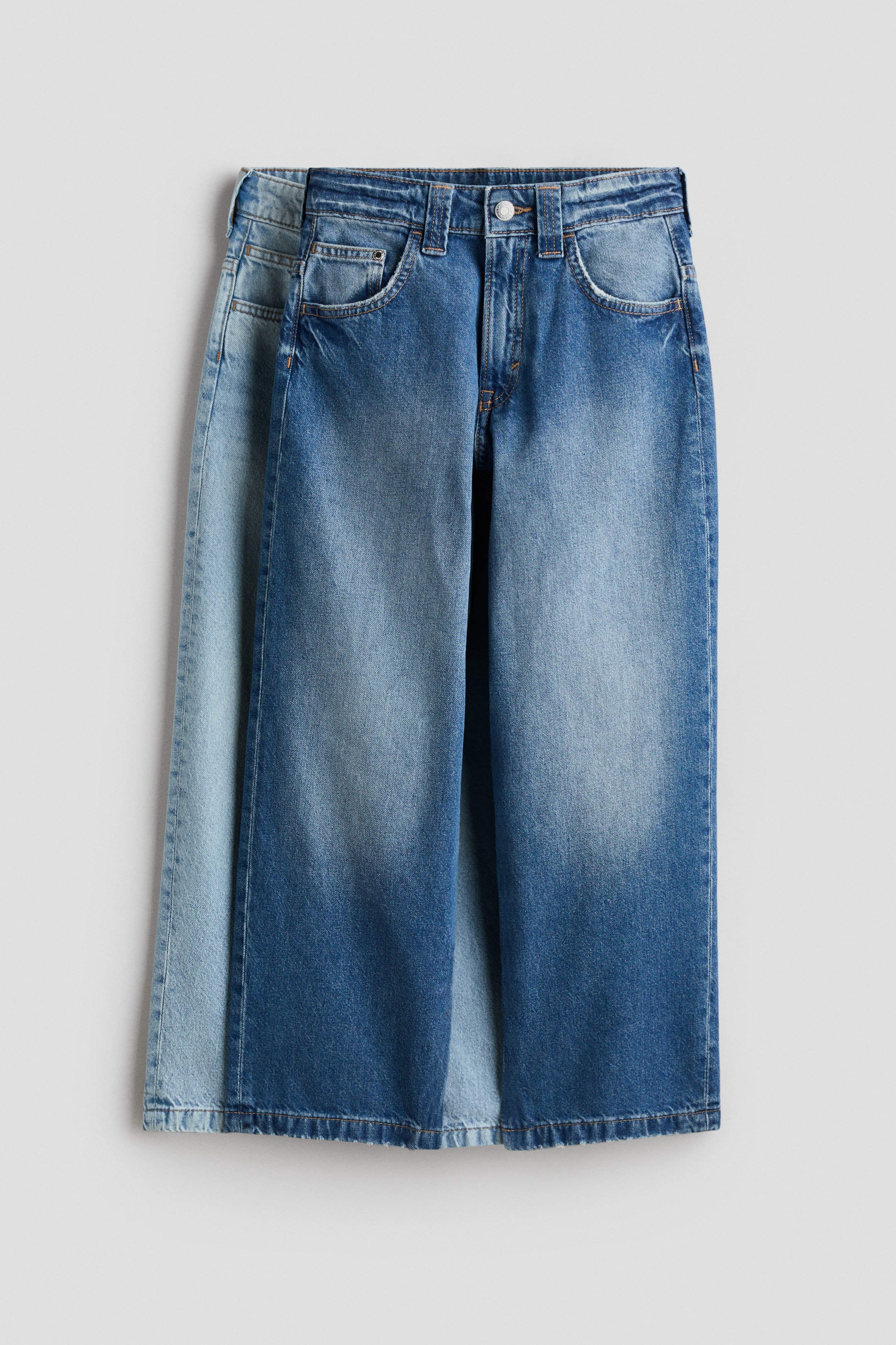 Se større billede: FORAN: Fem-lommers jeans i mellemblåt bomuldsdenim har et vasket look med lysere falmning på lårene og fremviser en løs pasform over hofte og lår med sænket skridt. Jeansene har lynlås og knaplukning i taljen samt to buede forlommer og en møntlomme.