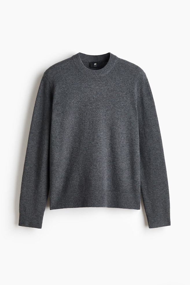 En mÃ¸rkegrÃ¥ strikket uldtrÃ¸je hÃ¦nger forfra og viser en klassisk silhuet i regular fit. Plagget har en rund crew-neck med ribkant, lange Ã¦rmer med ribkanter ved manchetterne og en matchende ribkant forneden. - 1