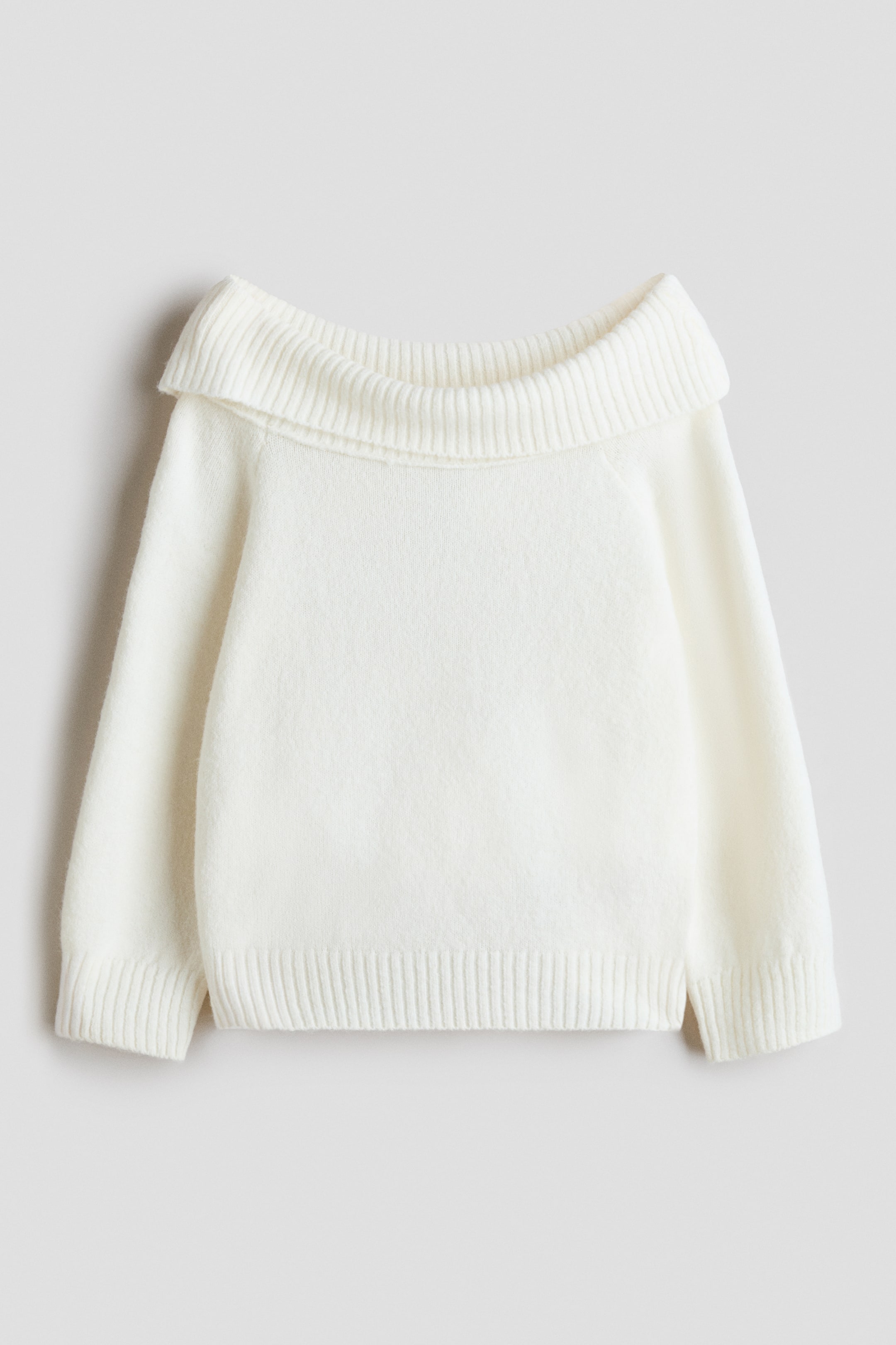 View larger image: A white sweater in a soft knit is shown from the front, featuring a wide, ribbed foldover neckline. The sweater features long sleeves with ribbed cuffs and a matching ribbed hem.