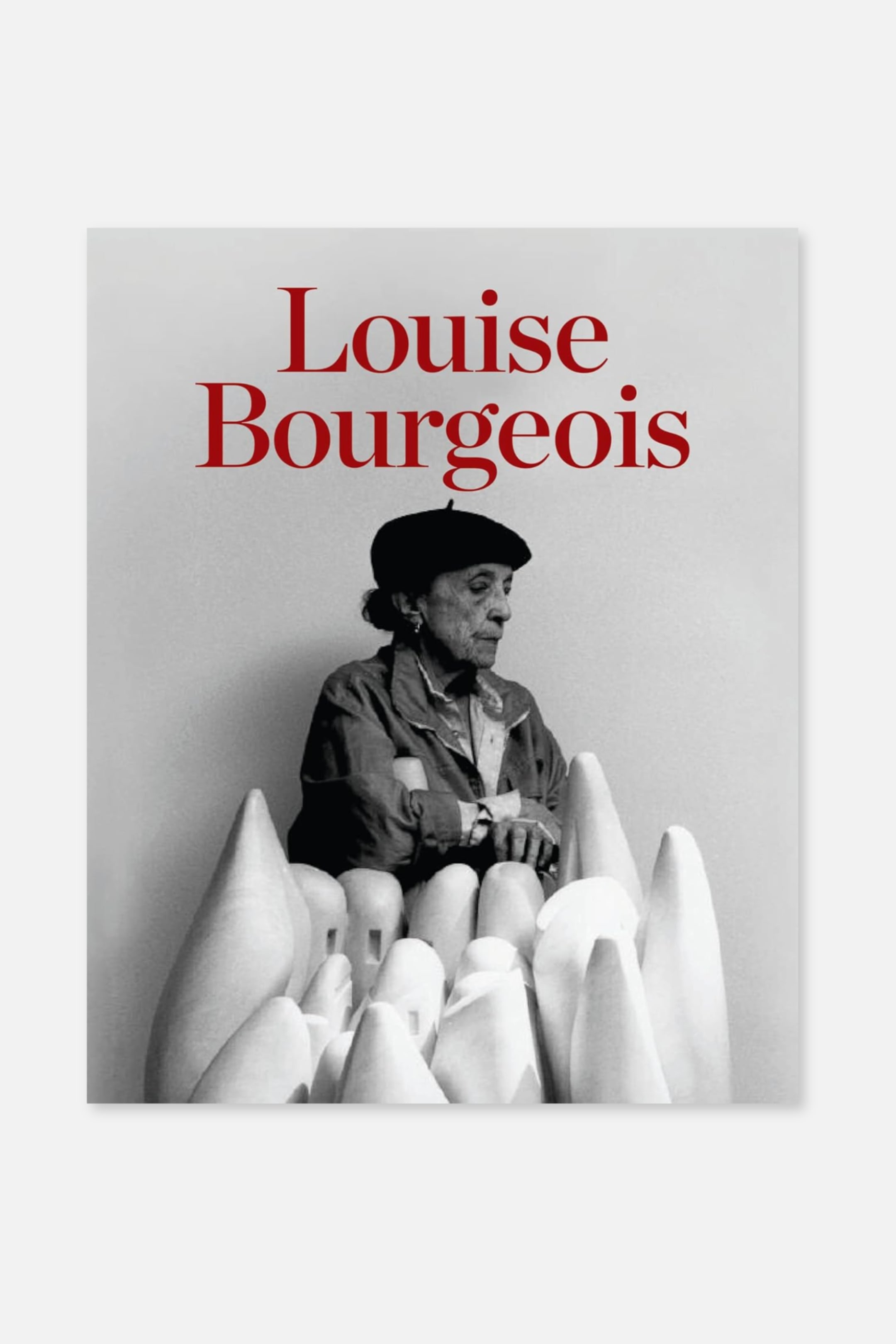 Größeres Bild anzeigen: Das Buchcover zeigt eine schwarz-weiße Fotografie von Louise Bourgeois, die einen dunklen Barett und eine Jacke trägt, während sie zwischen verschiedenen hellen, abstrakten skulpturalen Formen sitzt. Der Titel "Louise Bourgeois" erscheint in roten, serifenlosen Buchstaben oben auf dem Cover.