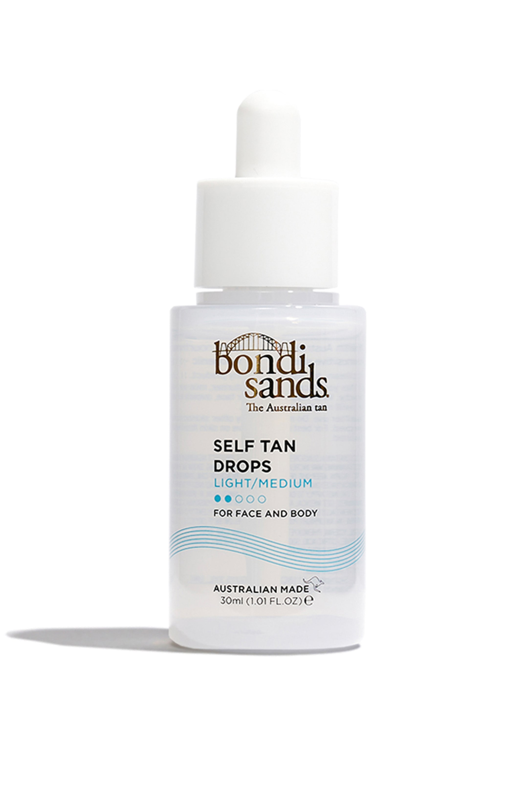 Se større billede: En klar, rektangulær flaske med Bondi Sands Self Tan Drops står oprejst, med en hvid pipettehætte. Etiketten viser "SELF TAN DROPS LIGHT/MEDIUM" i sort tekst, med to blå fyldte cirkler, der angiver nuancen, og bølgende blå linjer er trykt nær bunden.
