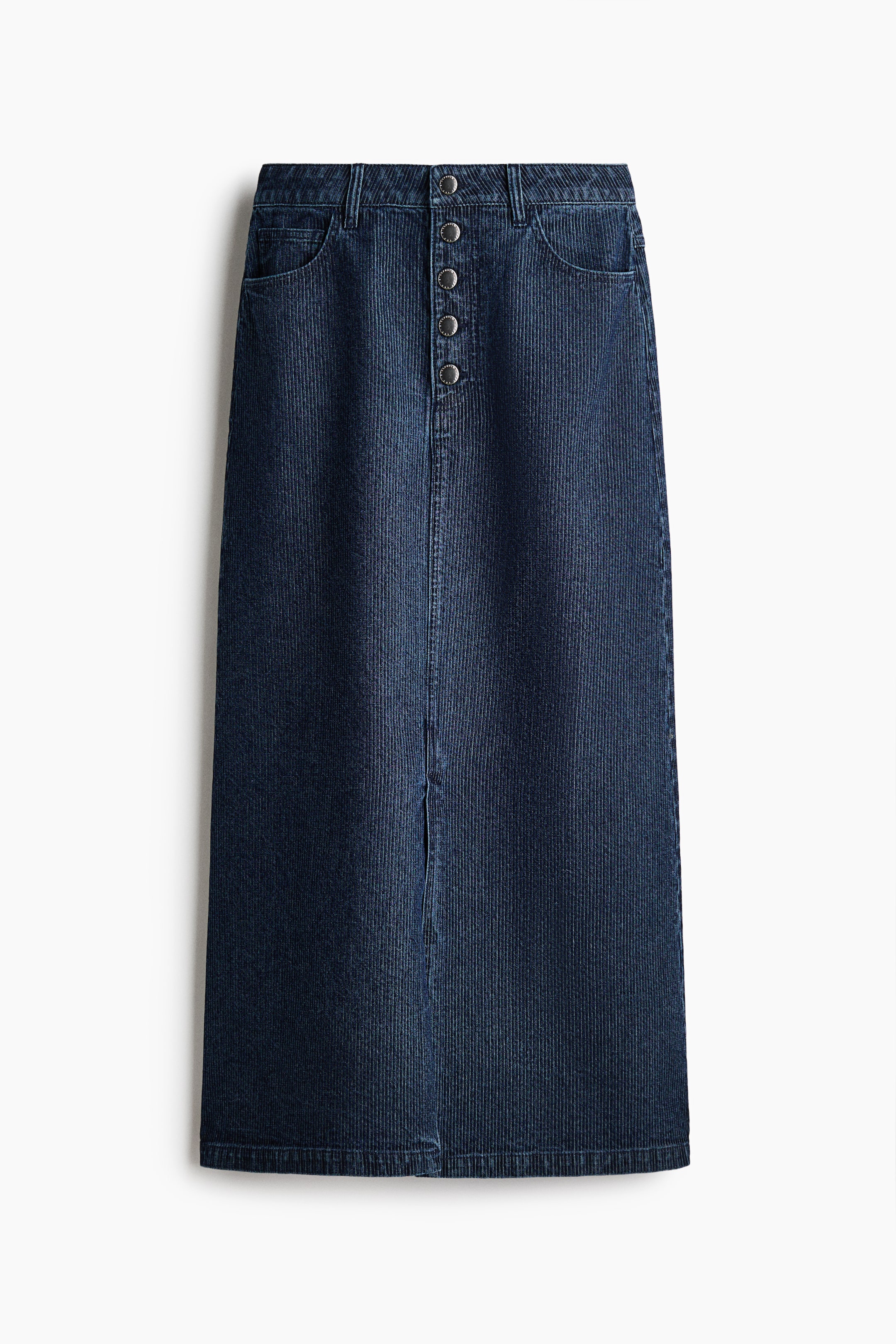 View larger image: A dark blue corduroy maxi skirt is shown from the front, featuring a high-waisted design with belt loops, front scoop pockets, and a five-button closure. The skirt has a straight silhouette with a vertical center seam leading down to a front split hem.