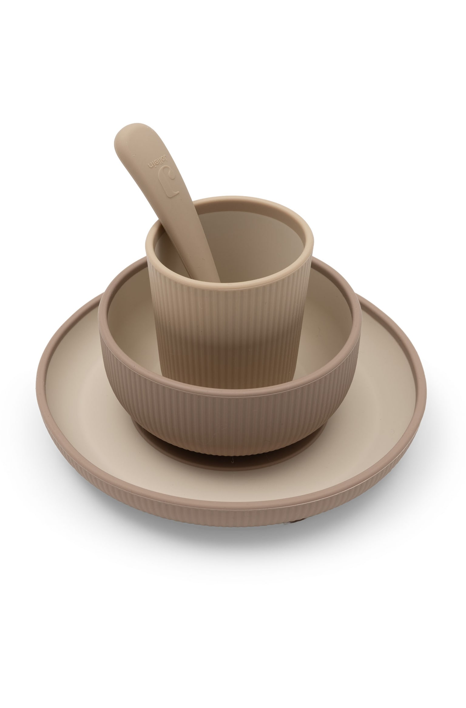 Un ensemble de vaisselle pour bébé en silicone est présenté dans une composition empilée, comprenant une assiette, un bol et une tasse dans un design bicolore taupe et beige. Les parois extérieures de chaque élément présentent une texture nervurée verticale, avec une cuillère en silicone assortie reposant dans la tasse. - 1