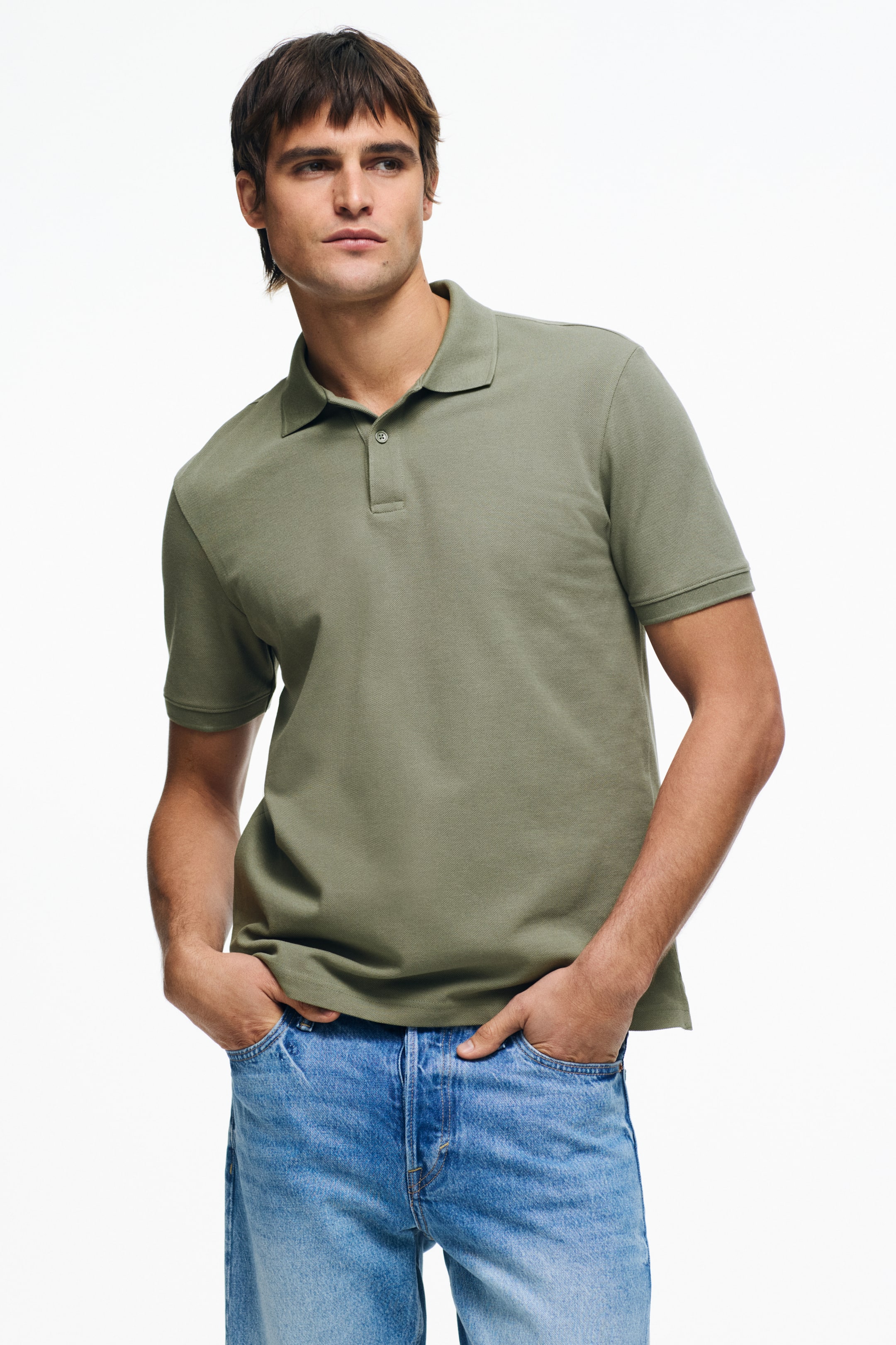 View larger image: An olive green polo shirt is showcased, featuring a pointed collar, a two-button placket, and short sleeves with ribbed cuffs. It exhibits a relaxed fit.