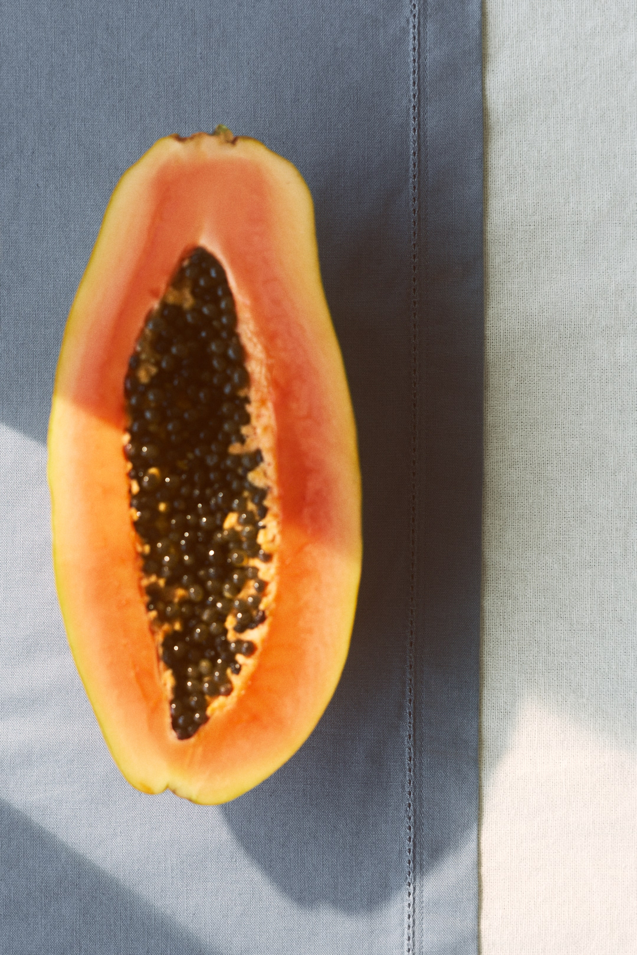 View larger image: A table runner is displayed from the front, highlighting a cotton weave. It features hemstitch detailing running vertically along an edge, dividing a blue-grey section from a lighter tone section, and is completed with a 2.5 cm folded hem.