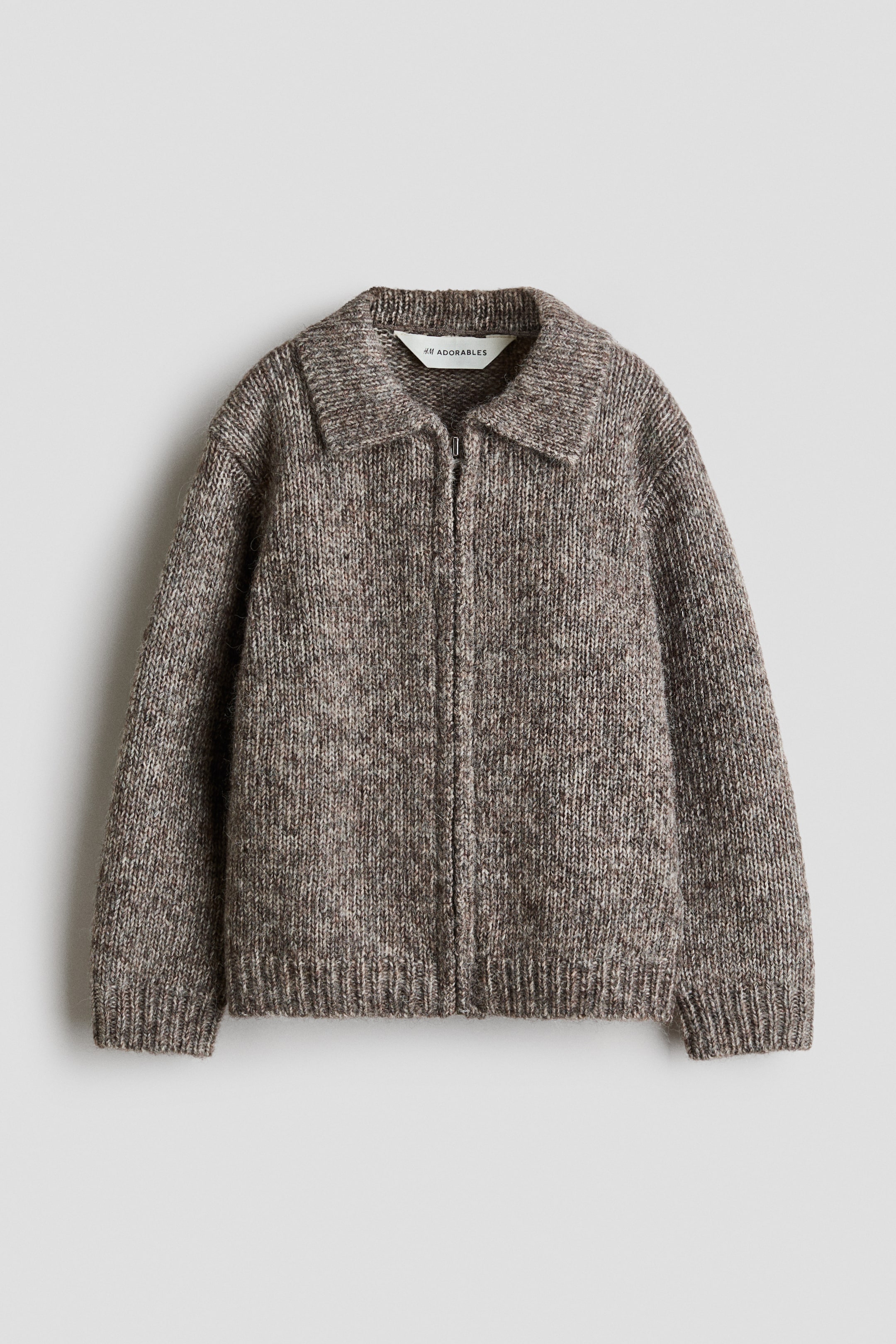 View larger image: A marled brown knit cardigan is facing forward, showcasing a flat collar, a full-length front zipper, and dropped shoulders. The cardigan features ribbed detailing at the cuffs and hem.