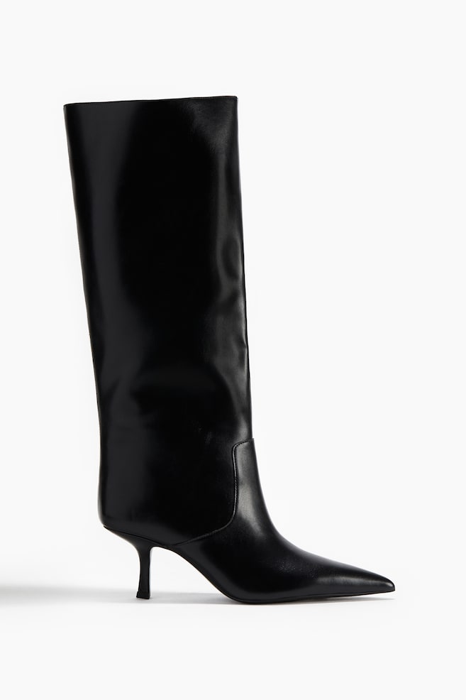 Ein polierter schwarzer Lederstiefel wird in Seitenansicht präsentiert, mit einem hohen Schaft, einer spitzen Zehenpartie und einem schlanken Kitten-Heel-Absatz. - 1