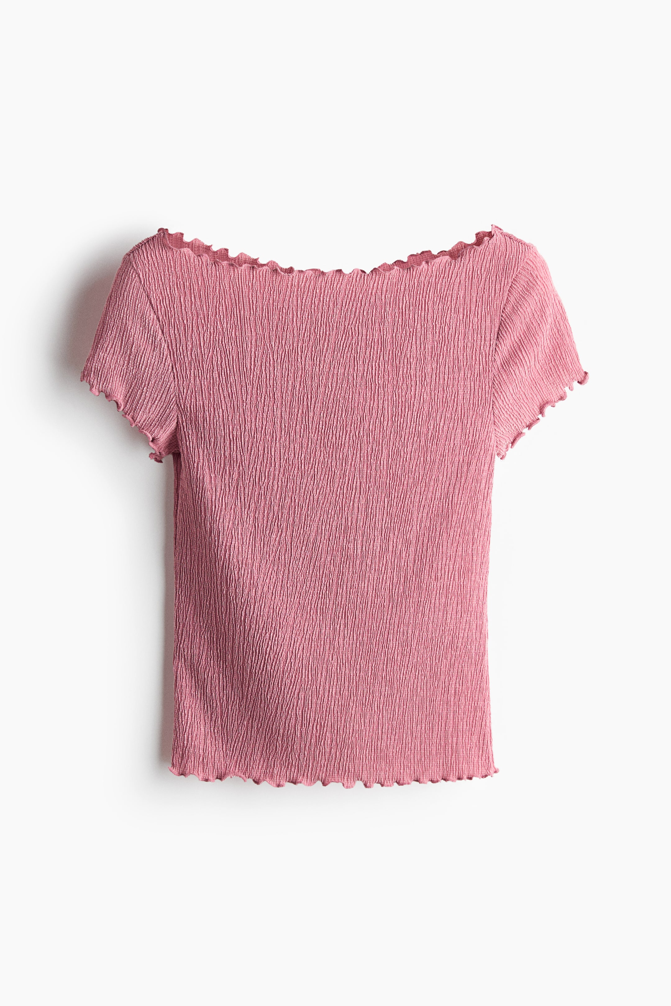 View larger image: The image showcases a pink top viewed from the front, highlighting a consistent crinkled texture throughout the fabric. It boasts a wide boat neckline, short sleeves, and a straight hem, each adorned with ruffled edges.