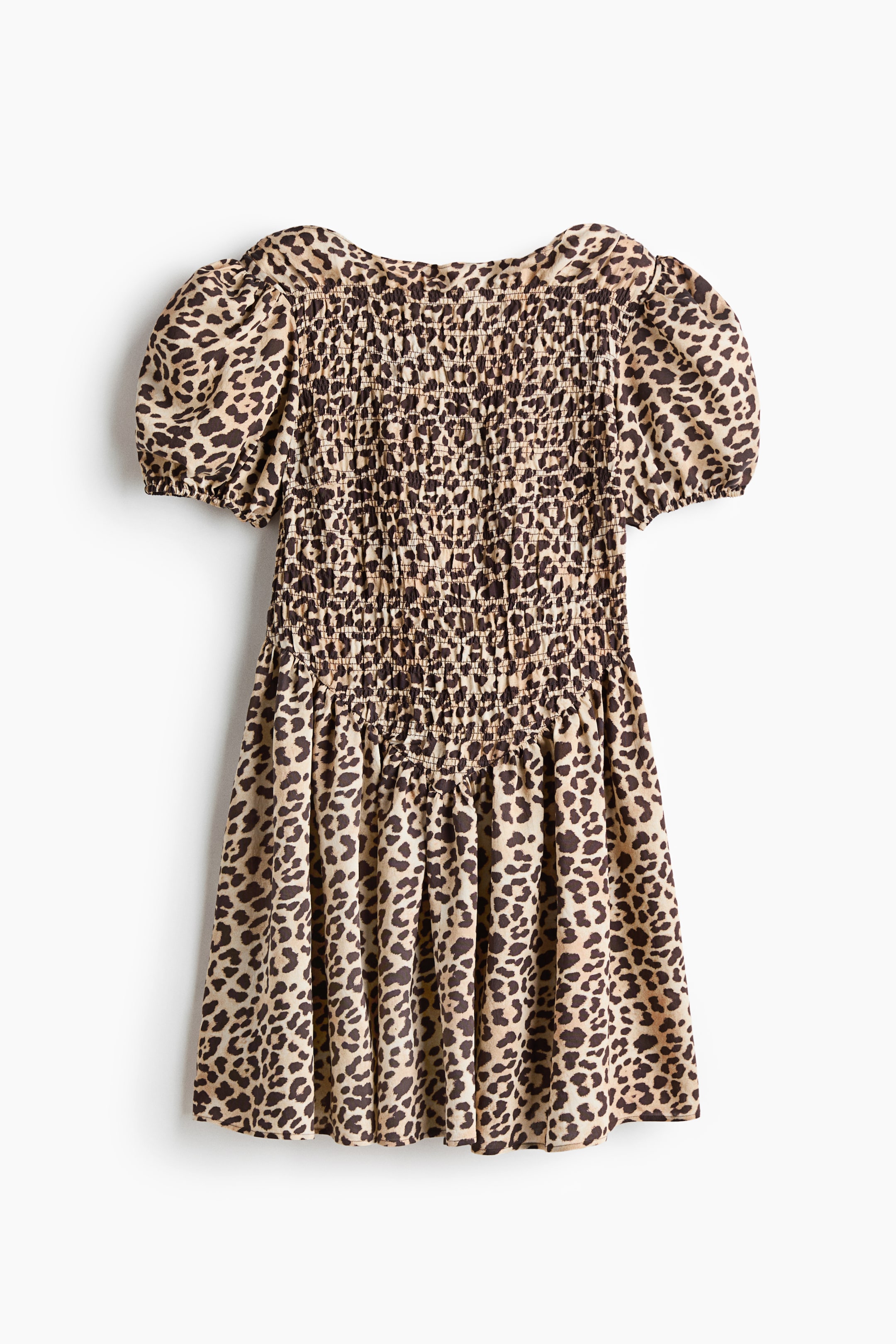 View larger image: A short dress in leopard print featuring a boat neckline and short puff sleeves with elastic cuffs. The dress showcases a smocked bodice, a gathered V-shaped seam at the front waist, and a flared skirt.