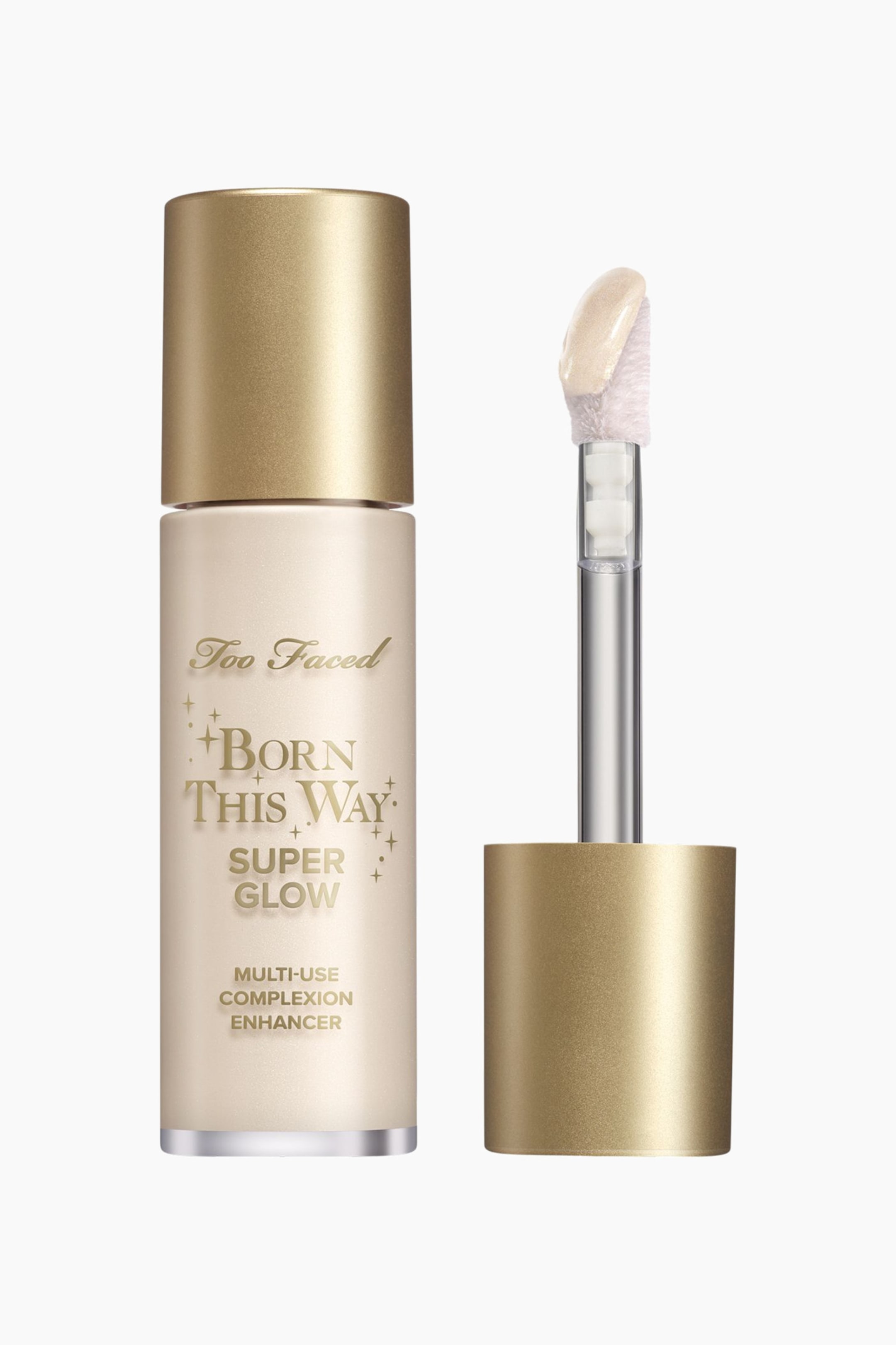 Visa större bild: En Too Faced Born This Way Super Glow Multi-Use Complexion Enhancer visar upp en frostad, ljusbeige flaska med ett metalliskt guldfärgat lock och guldtext. Dess löstagbara applikator med hjorthov är utrustad med en silverstam, en metalliskt guldfärgad bas och är mättad med en skimrande, ljusbeige produkt.