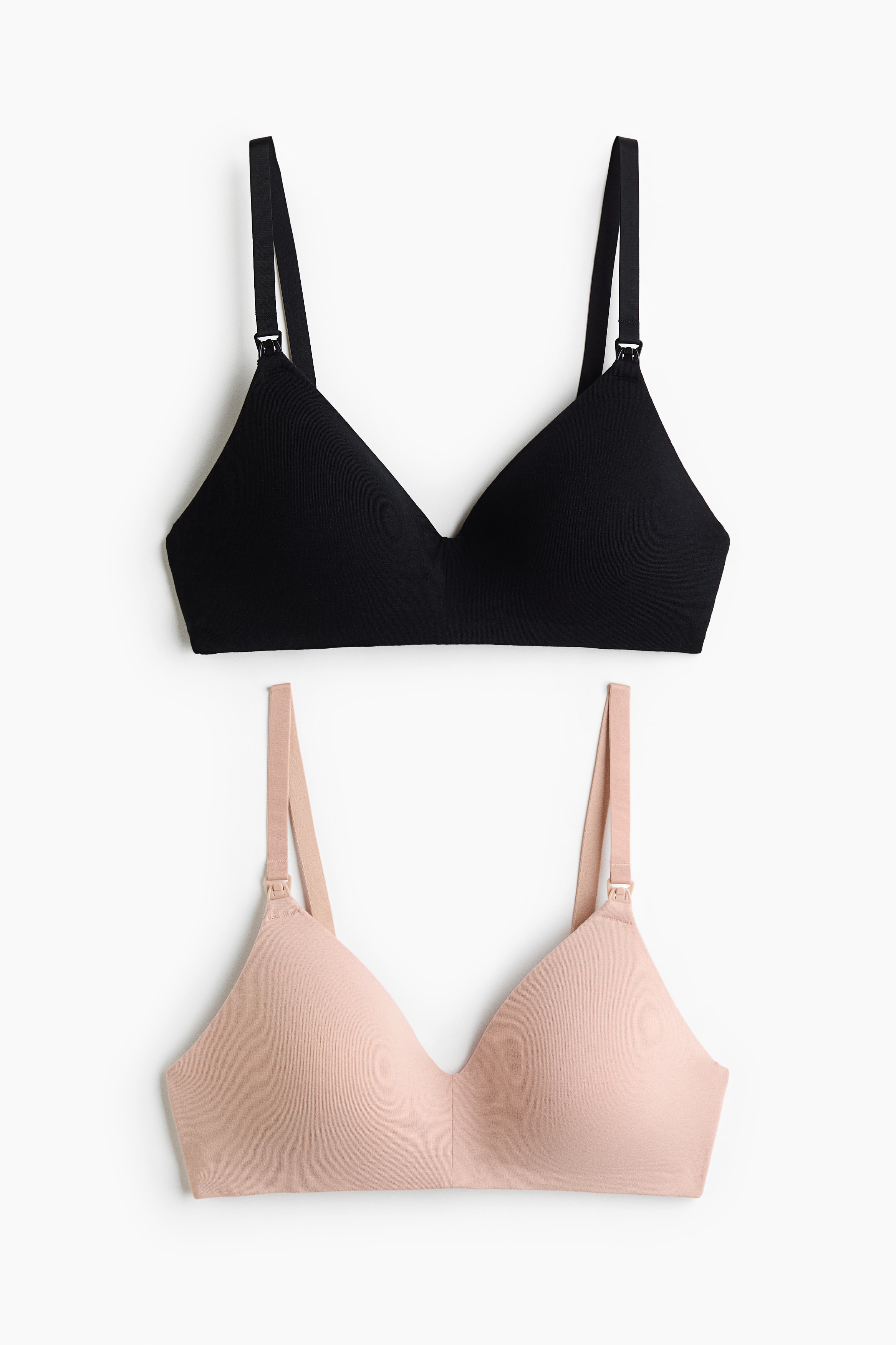 A soft, black non-wired nursing bra is being worn by the model. It features adjustable shoulder straps with visible nursing clips and lightly padded cups, providing a smooth silhouette.