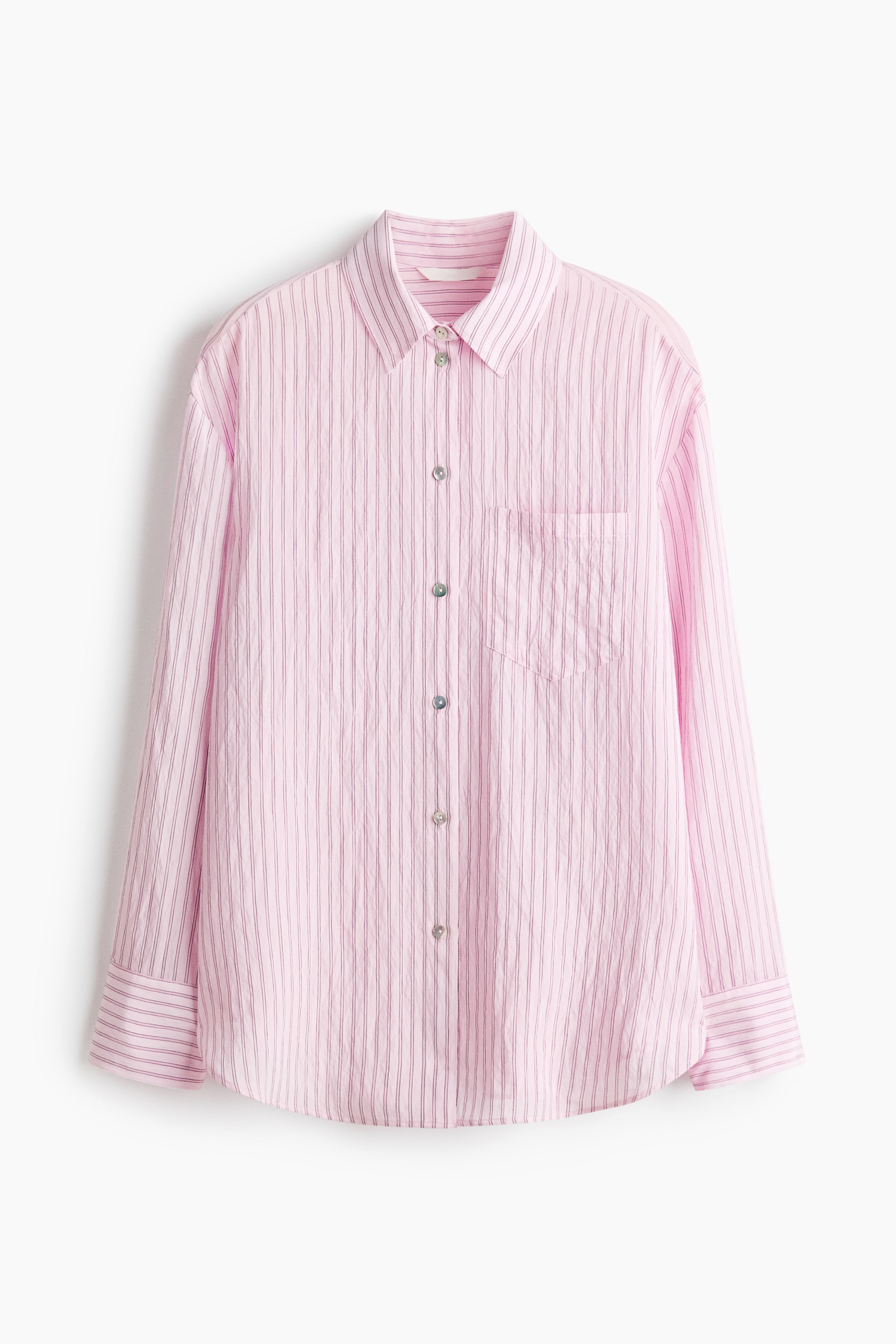 Ver imagen más grande: Una camisa rosa de manga larga se muestra de frente, con finas rayas verticales oscuras y una textura sutilmente arrugada. Está diseñada con un cuello en punta, una tapeta completa de botones con botones iridiscentes y un bolsillo de parche en el pecho izquierdo.