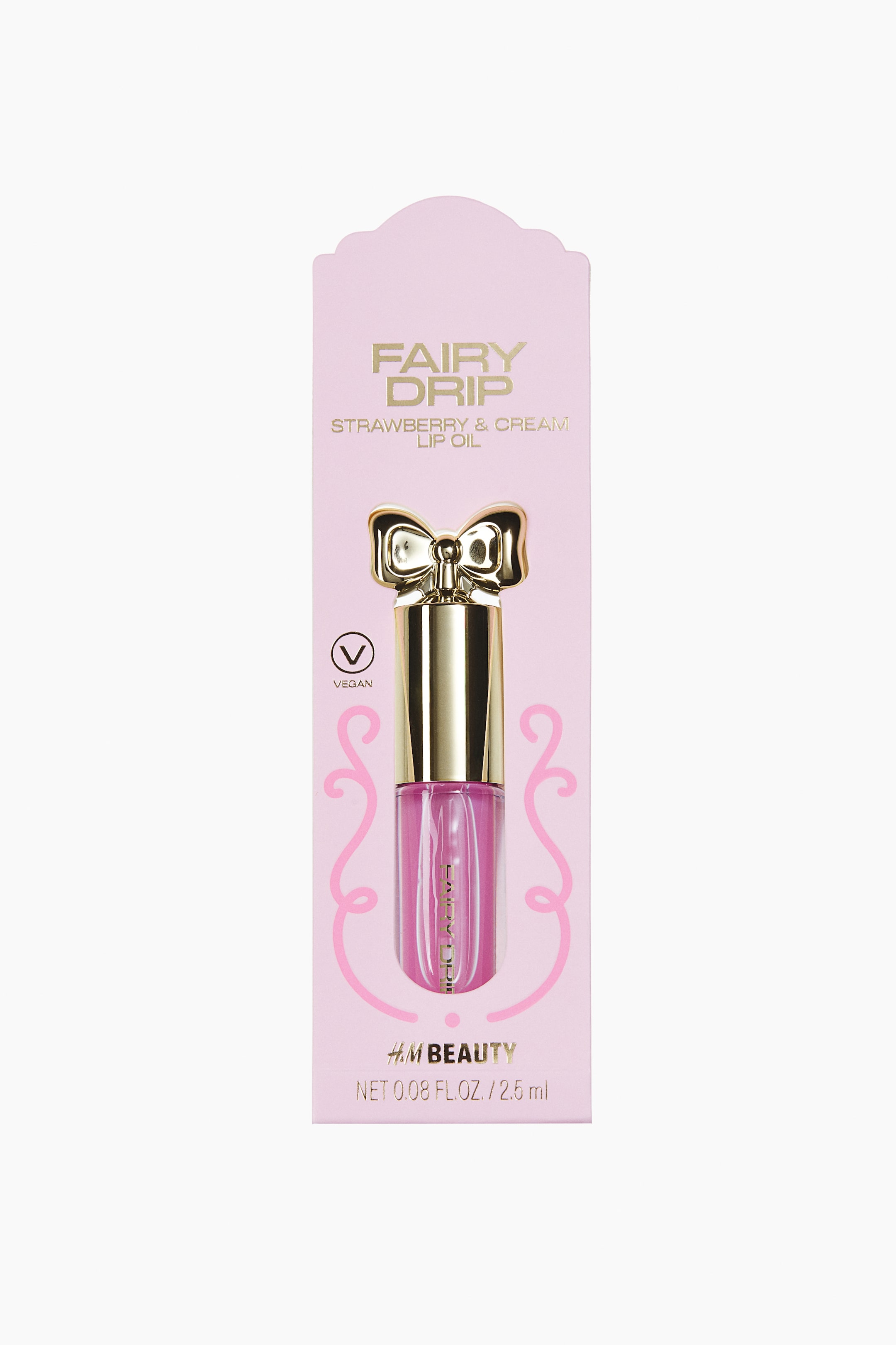 View larger image: A front-facing view of a lip oil container featuring a clear tube filled with a sheer pink gloss, topped with a metallic gold cap shaped like a bow. The product is mounted on a light pink cardboard backing with gold text and a vegan symbol.
